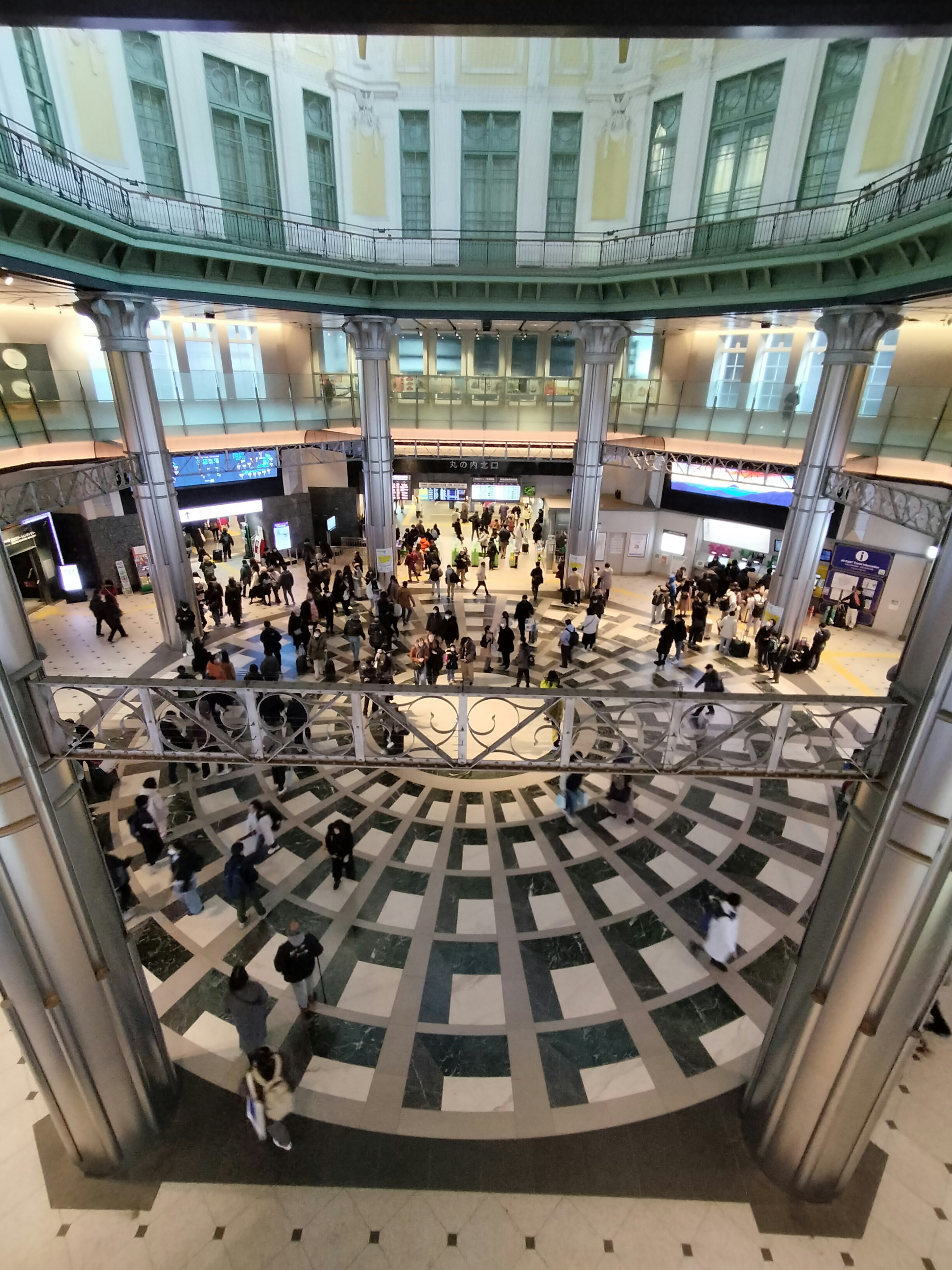 Spacious train station hall bustling with people circular design and high ceiling features