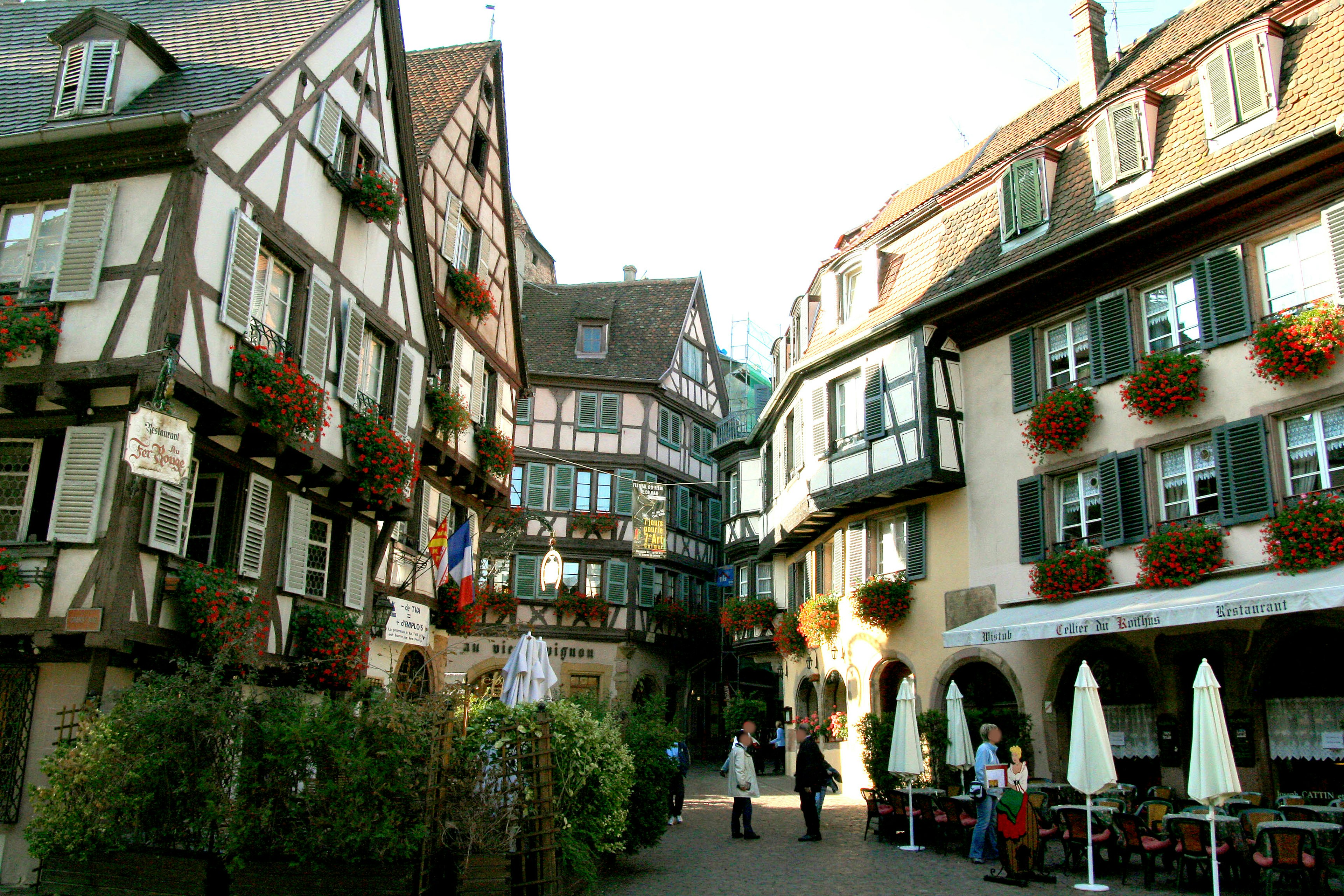 Calle encantadora con casas de entramado de madera y jardineras con flores