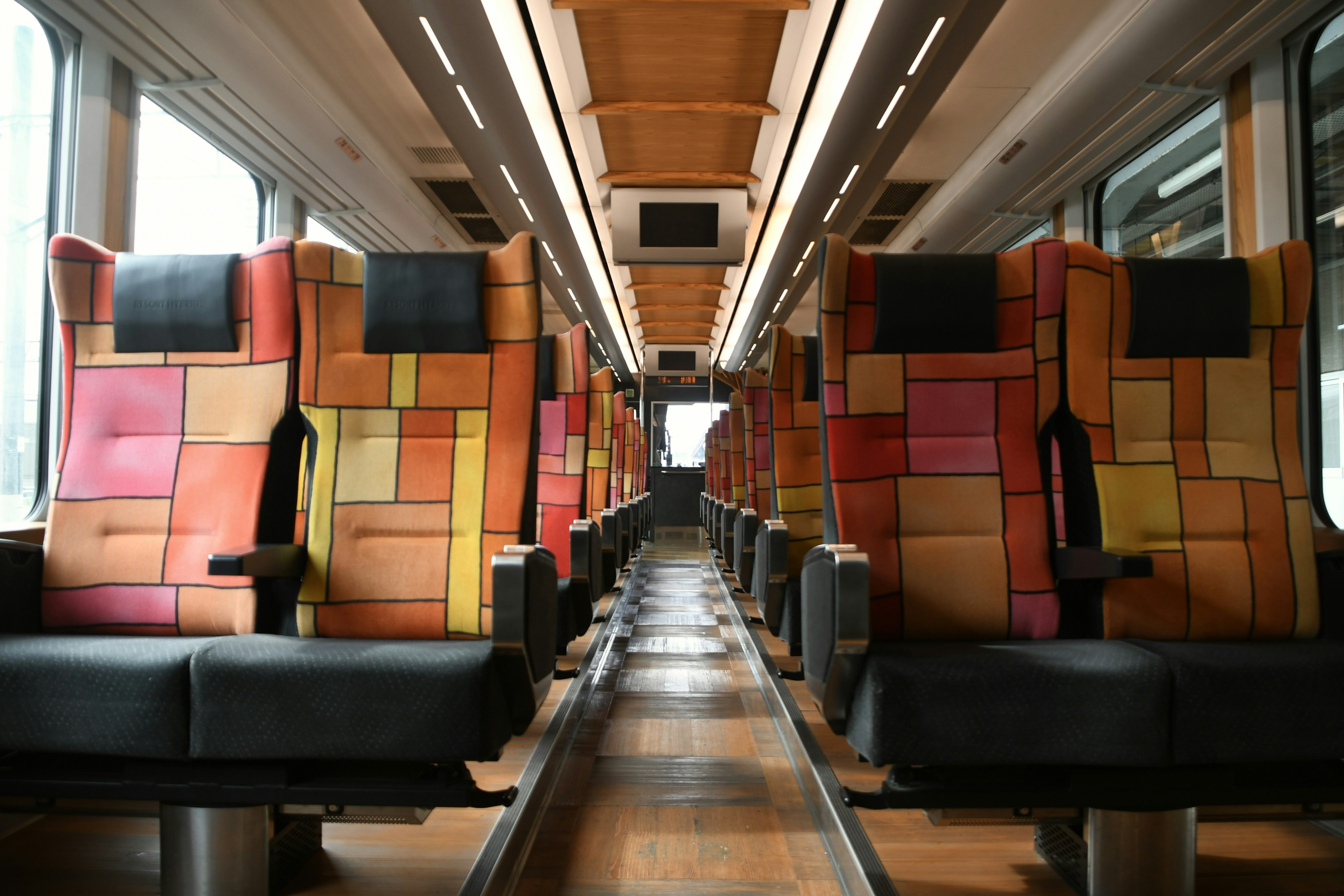 Train carriage featuring colorful patterned seats