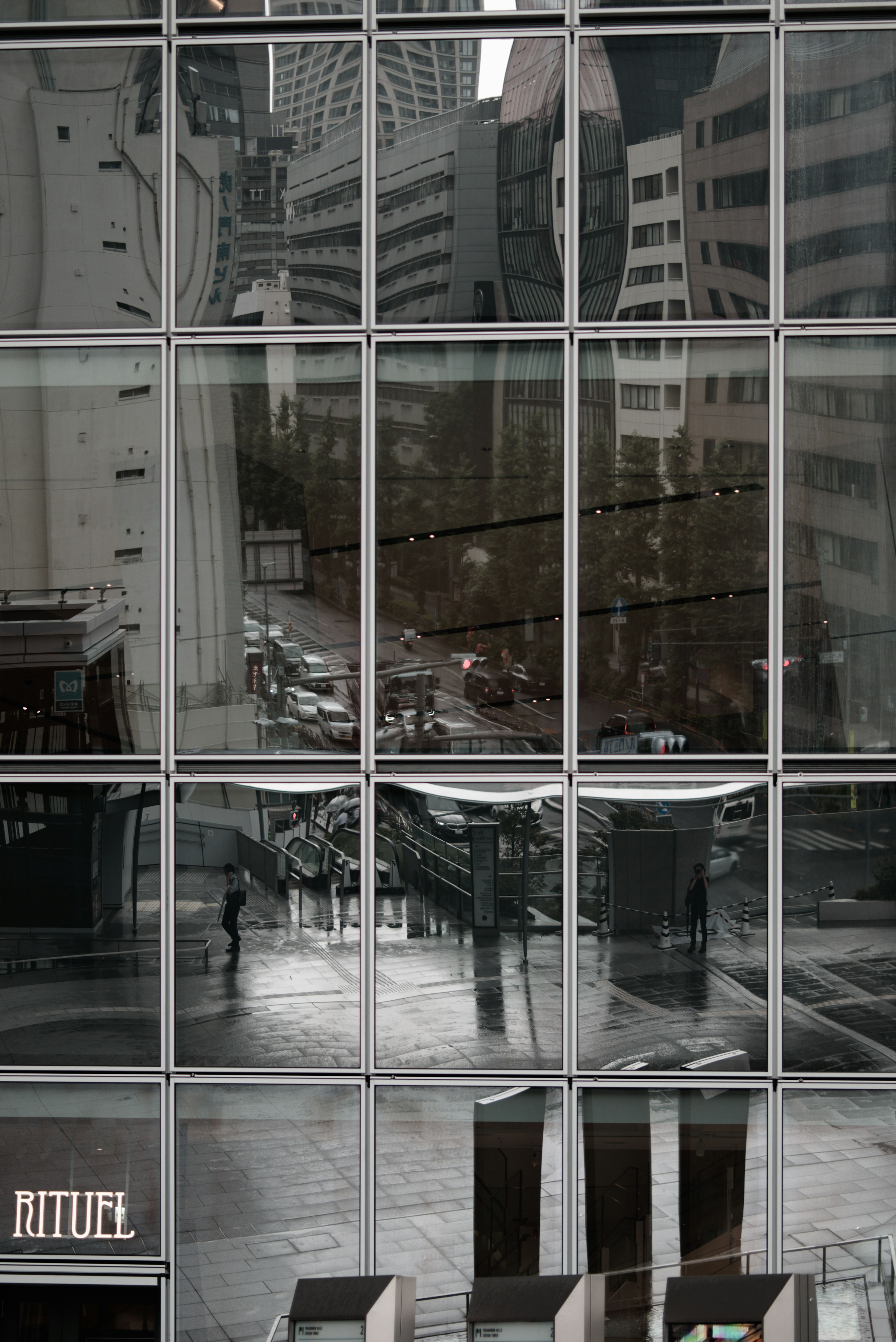 Cityscape and human silhouette reflected in a building's glass