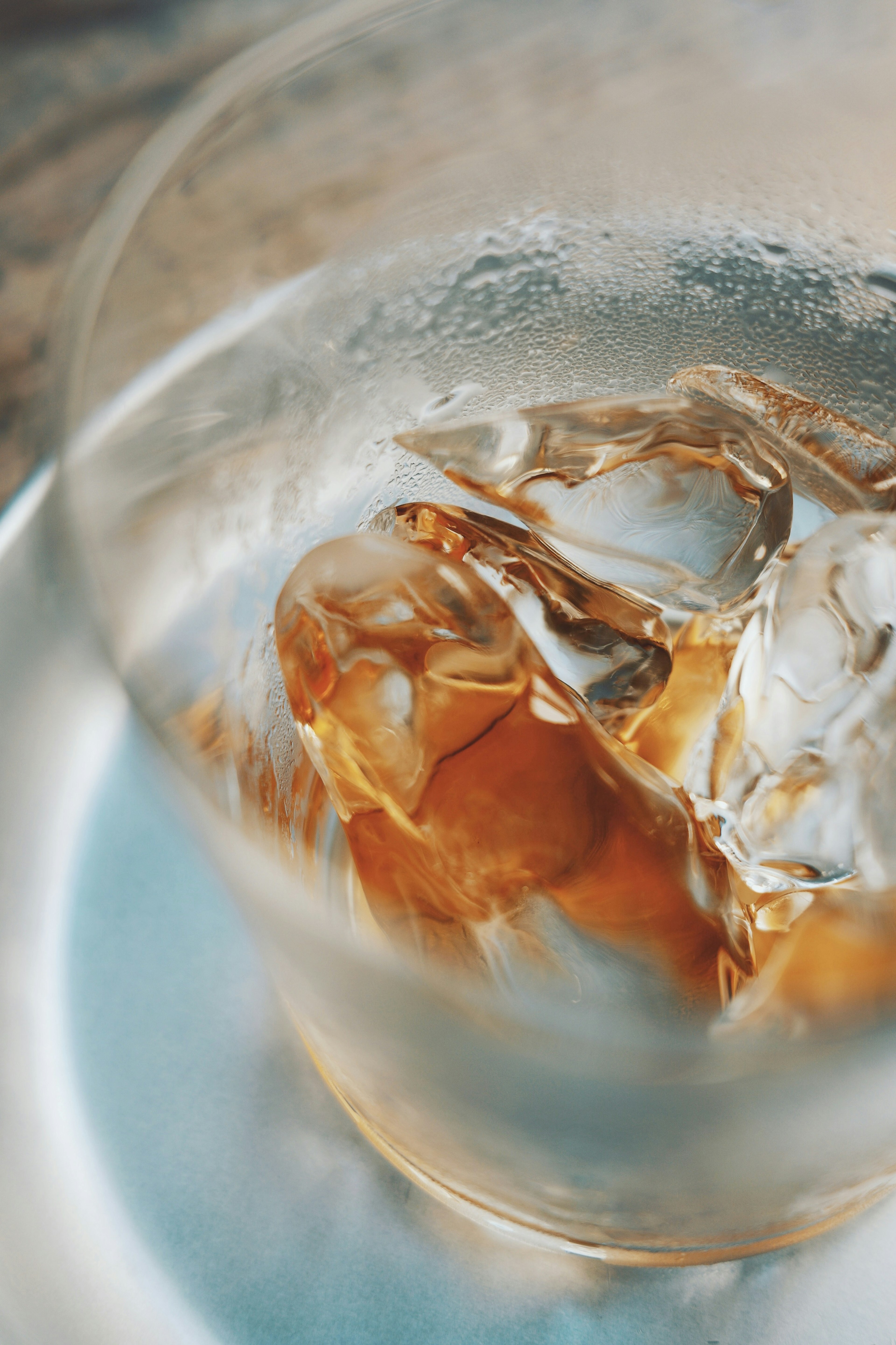 Acercamiento a un vaso con hielo y una bebida marrón