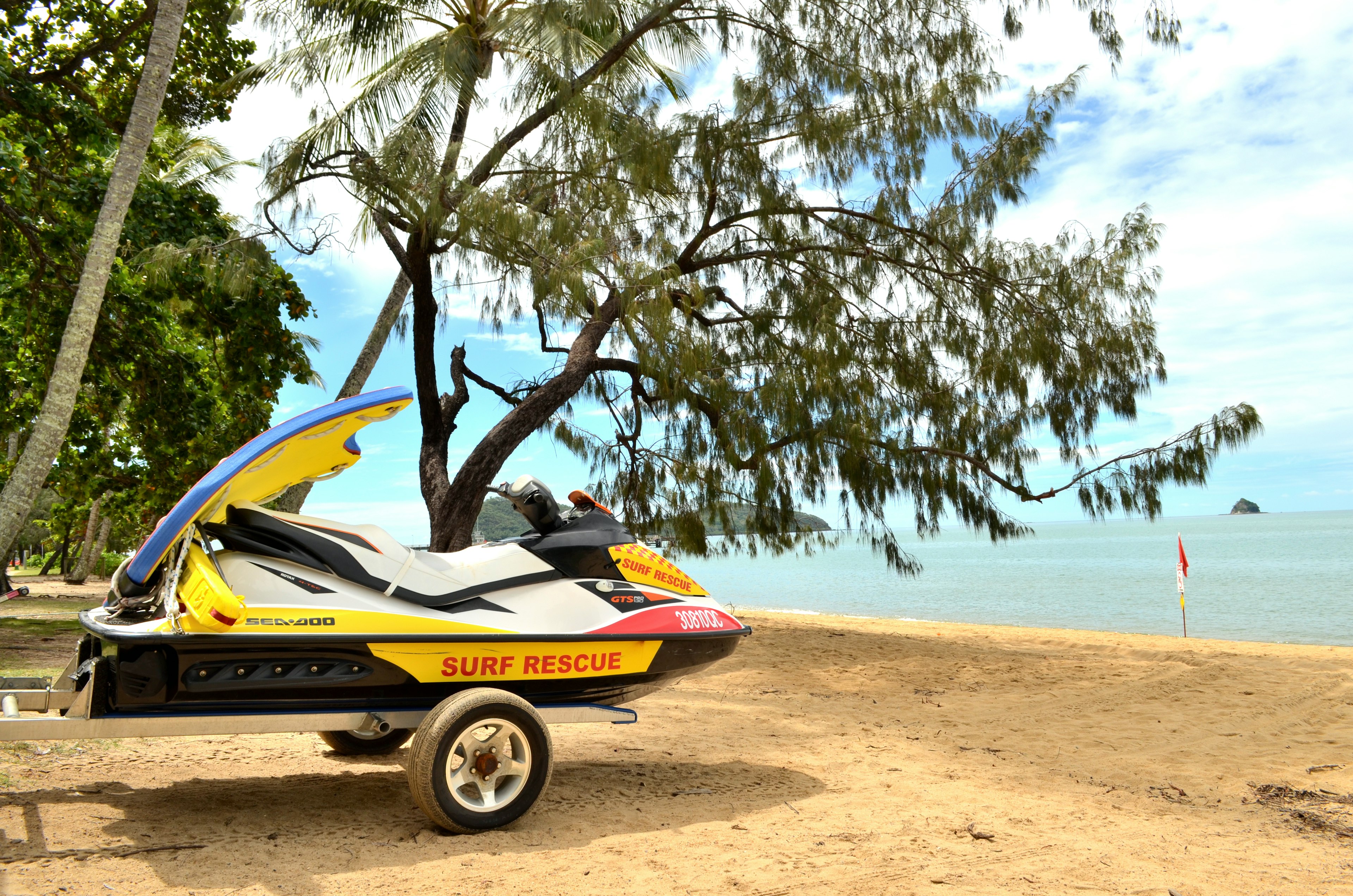 Rescue jet ski on the beach with trees in the background