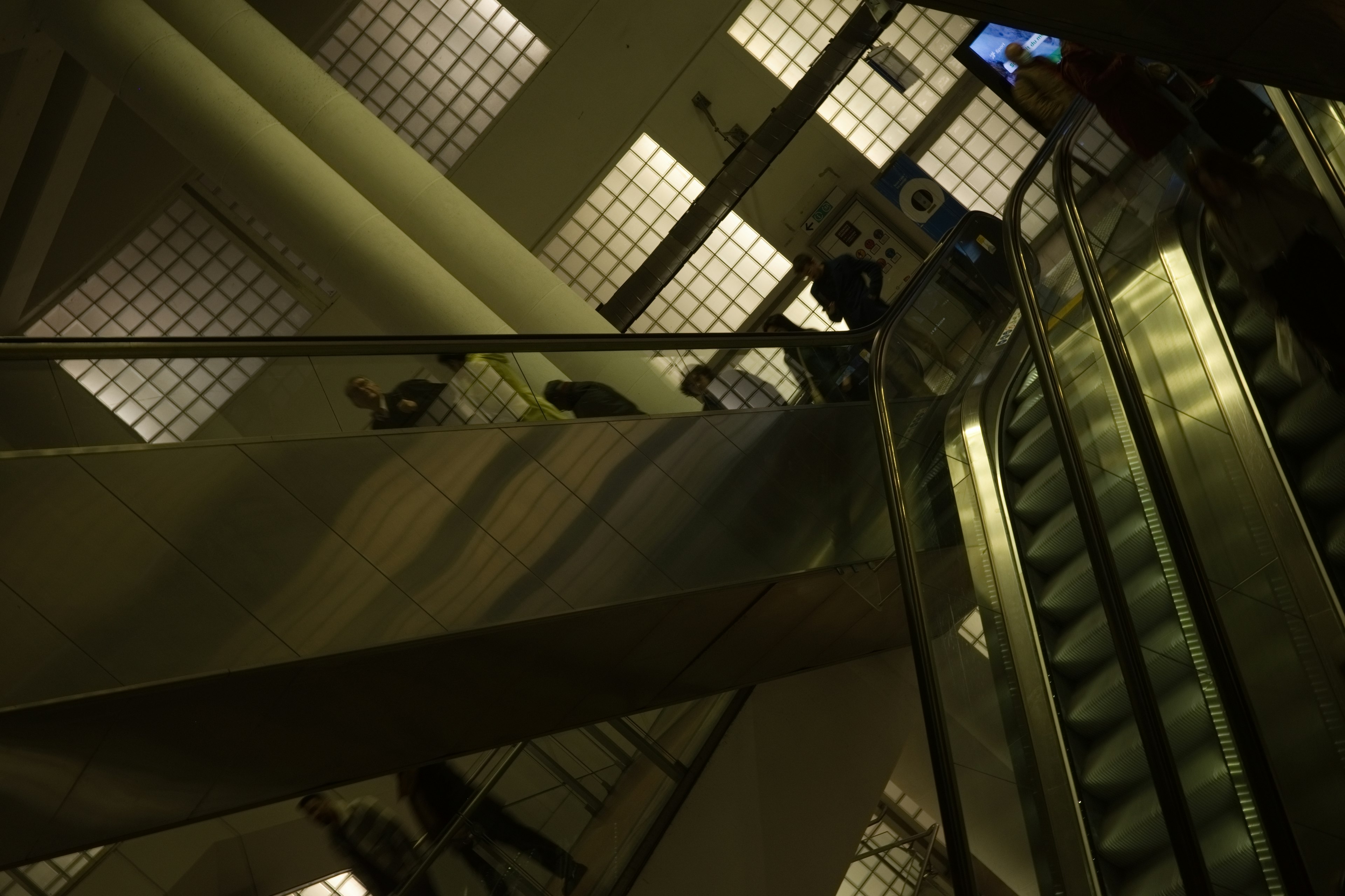 Interior view of a modern building featuring an escalator and large windows