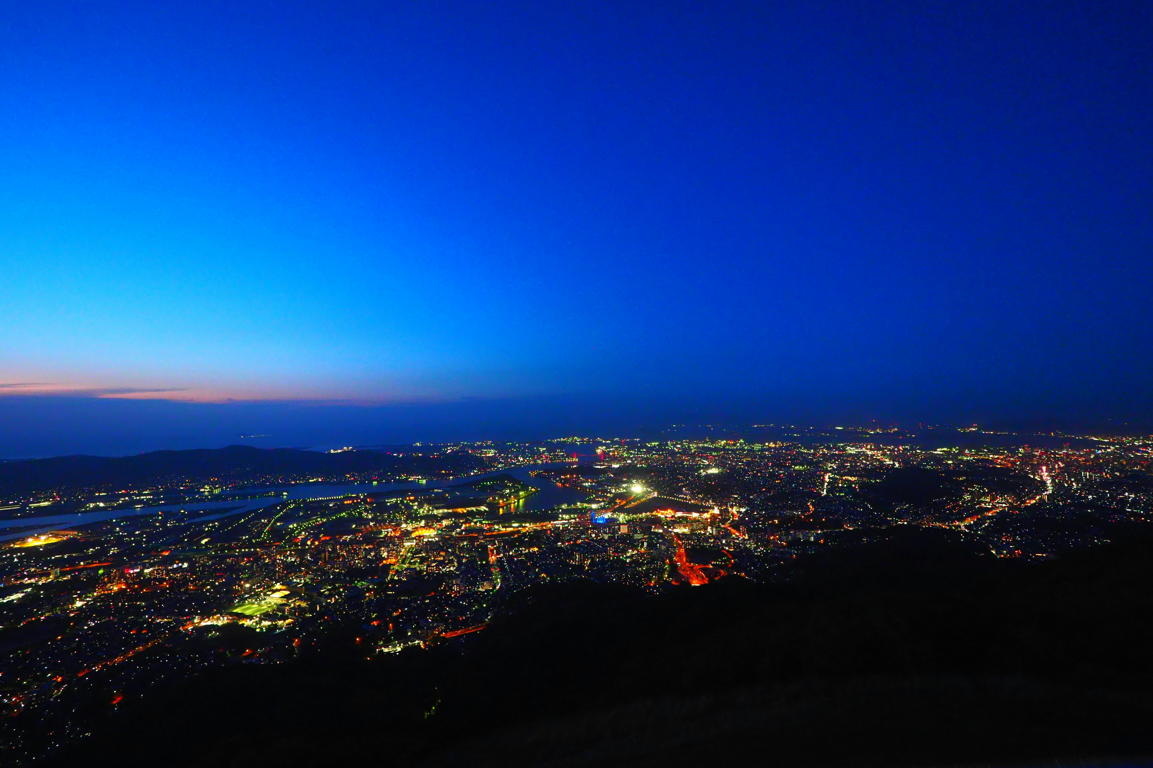 美麗的夜景城市風光，從藍色到黑色的漸變天空，閃爍的城市燈光