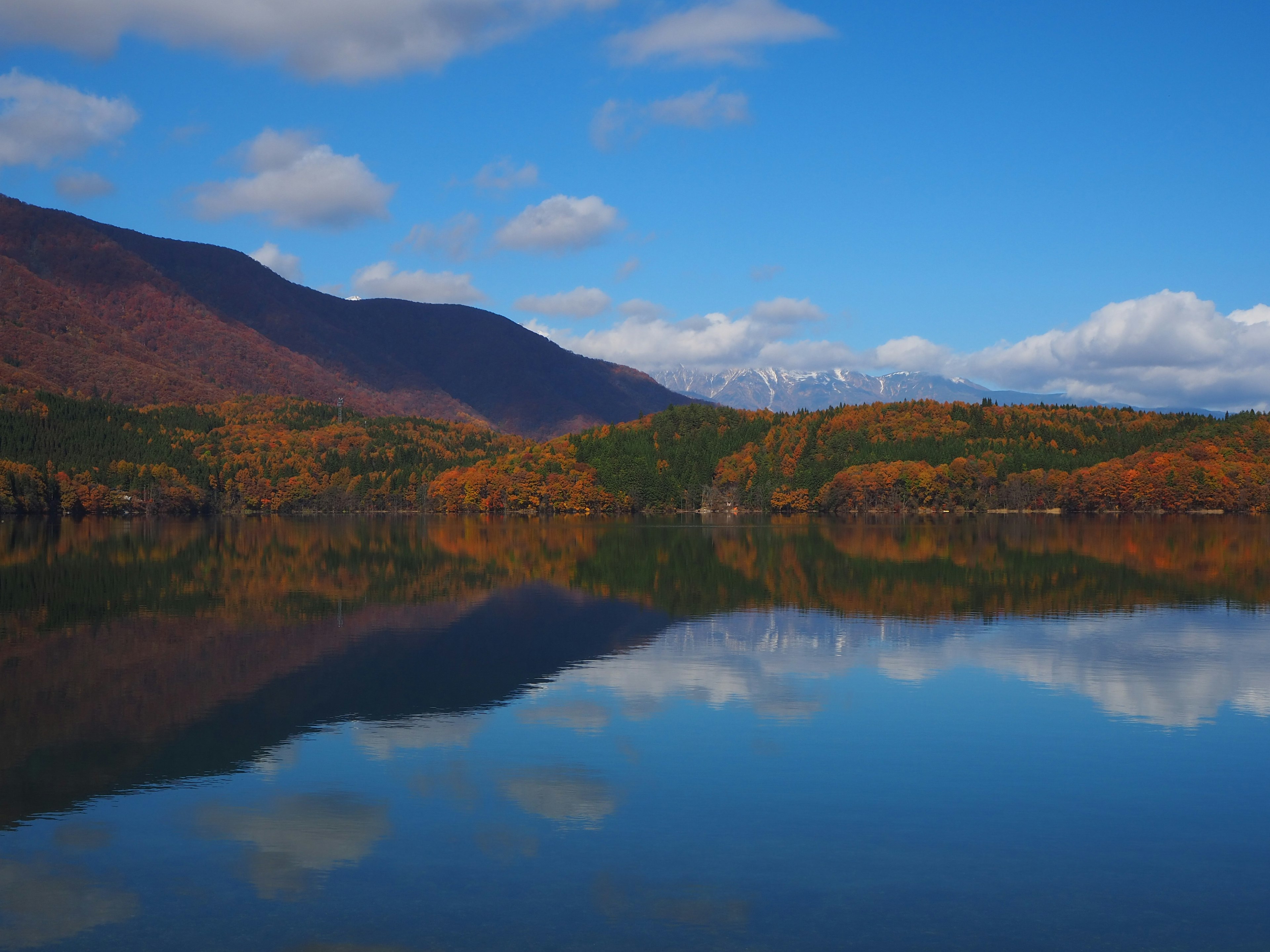 Malersicher Blick auf Berge mit Herbstfarben, die sich in einem ruhigen See spiegeln