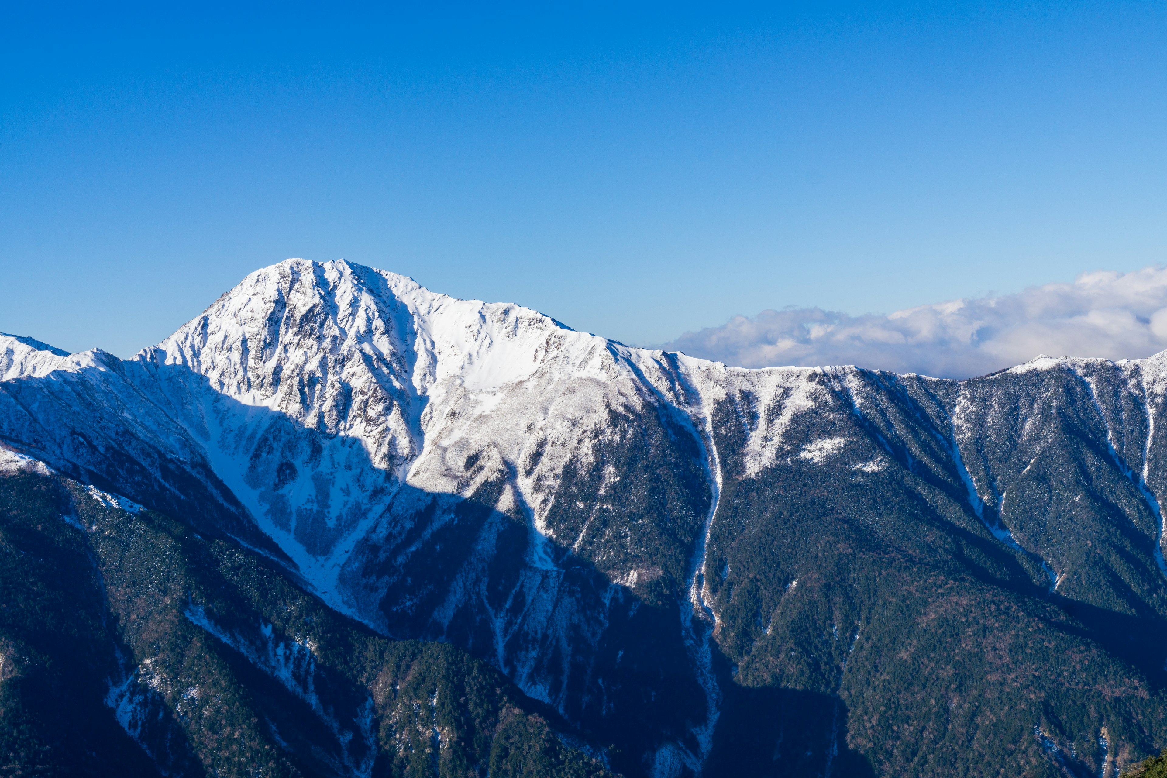 Montagnes enneigées sous un ciel bleu clair