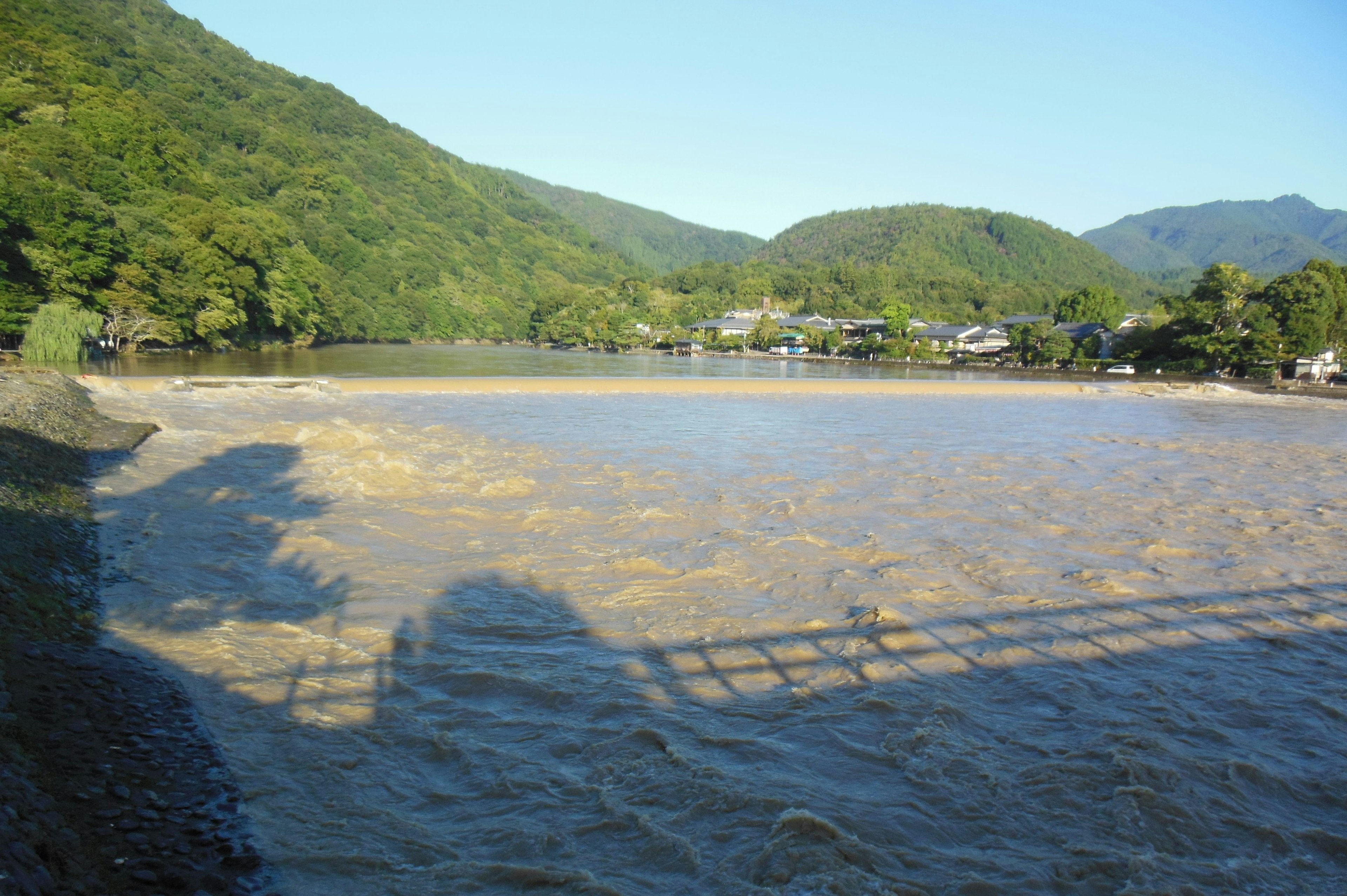 河流穿过绿色山脉，蓝天清晰