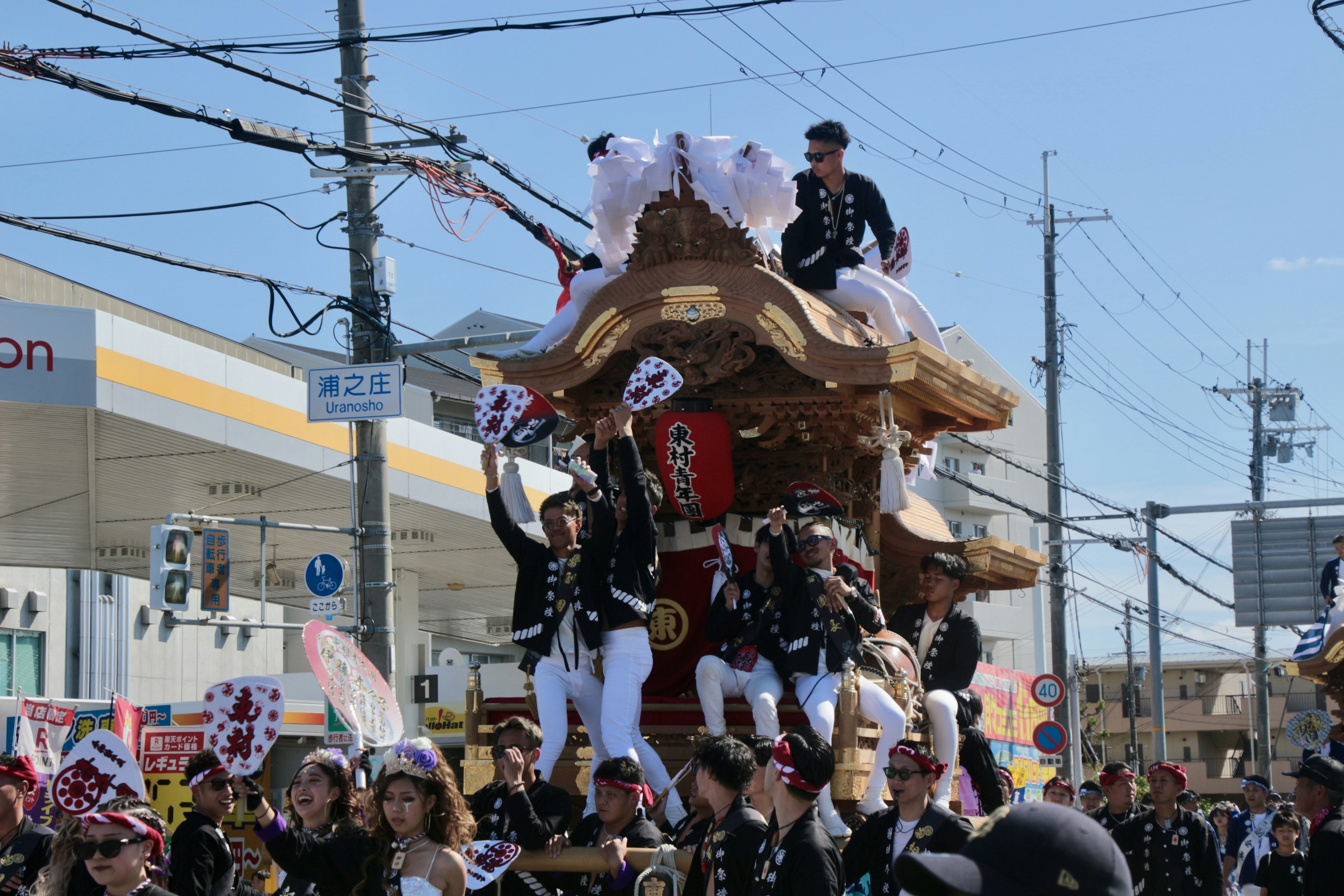 Orang-orang mengangkat kuil portable selama parade festival