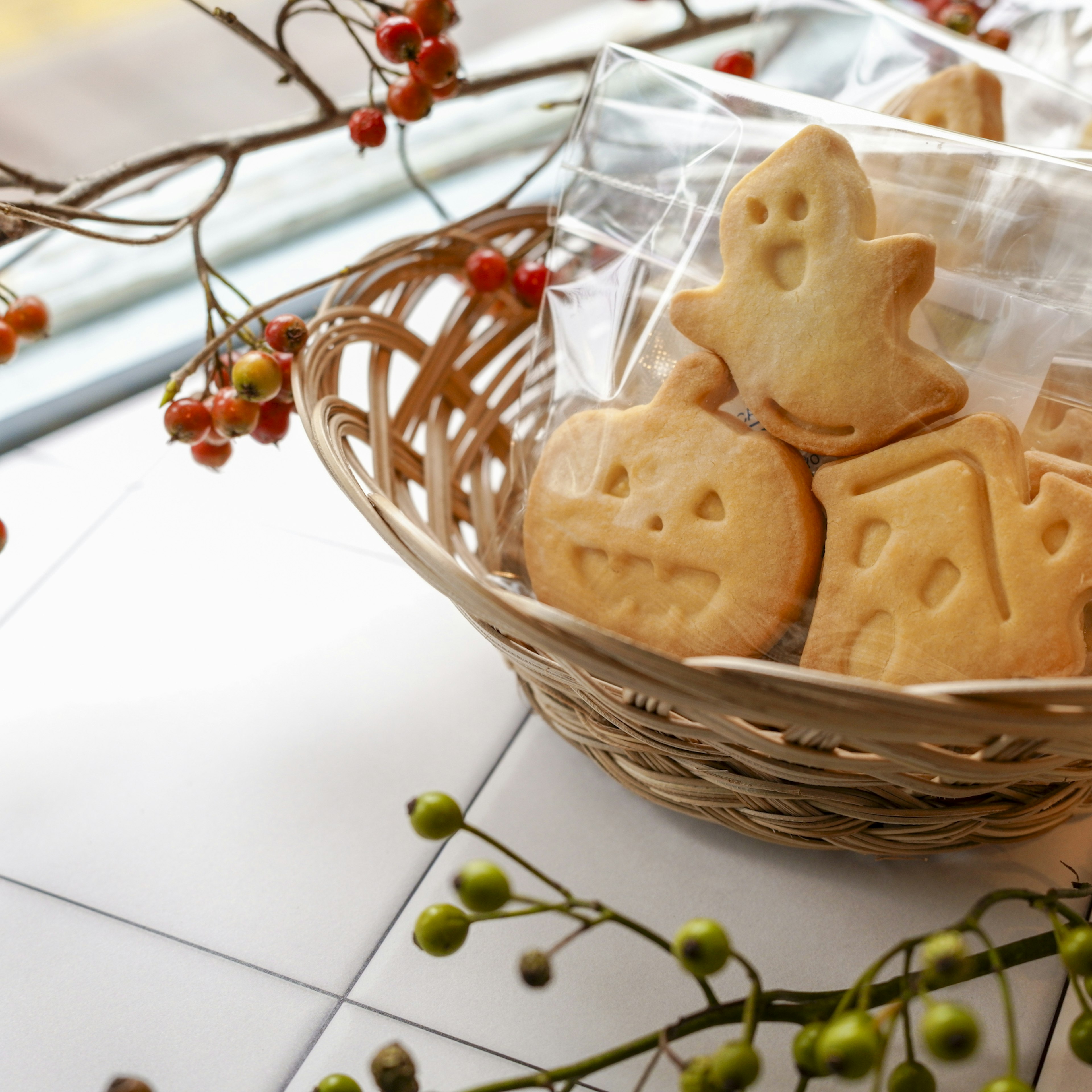 かごに入ったハロウィンの形をしたクッキーと飾りの枝