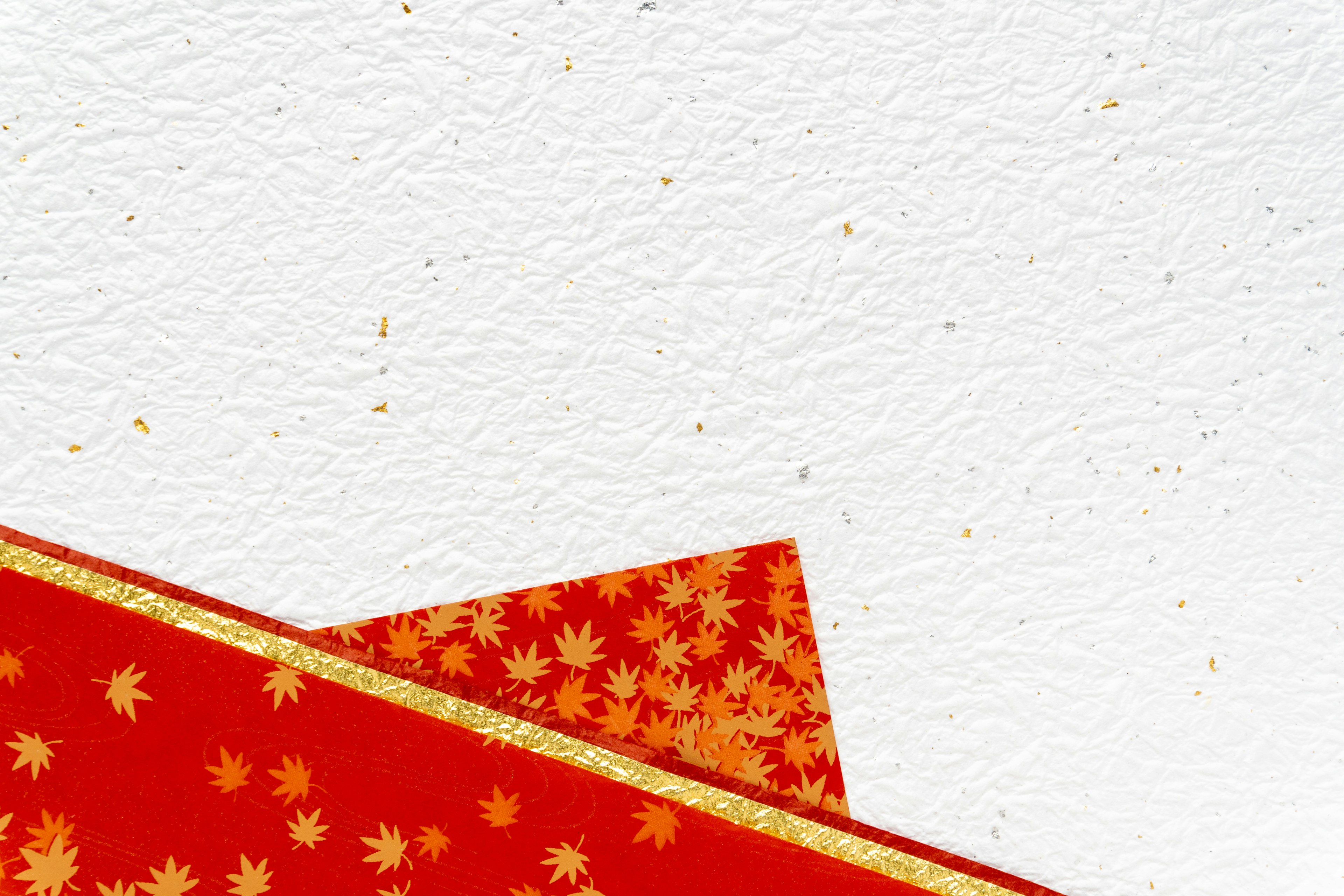 Red patterned paper corner with gold trim on a white background