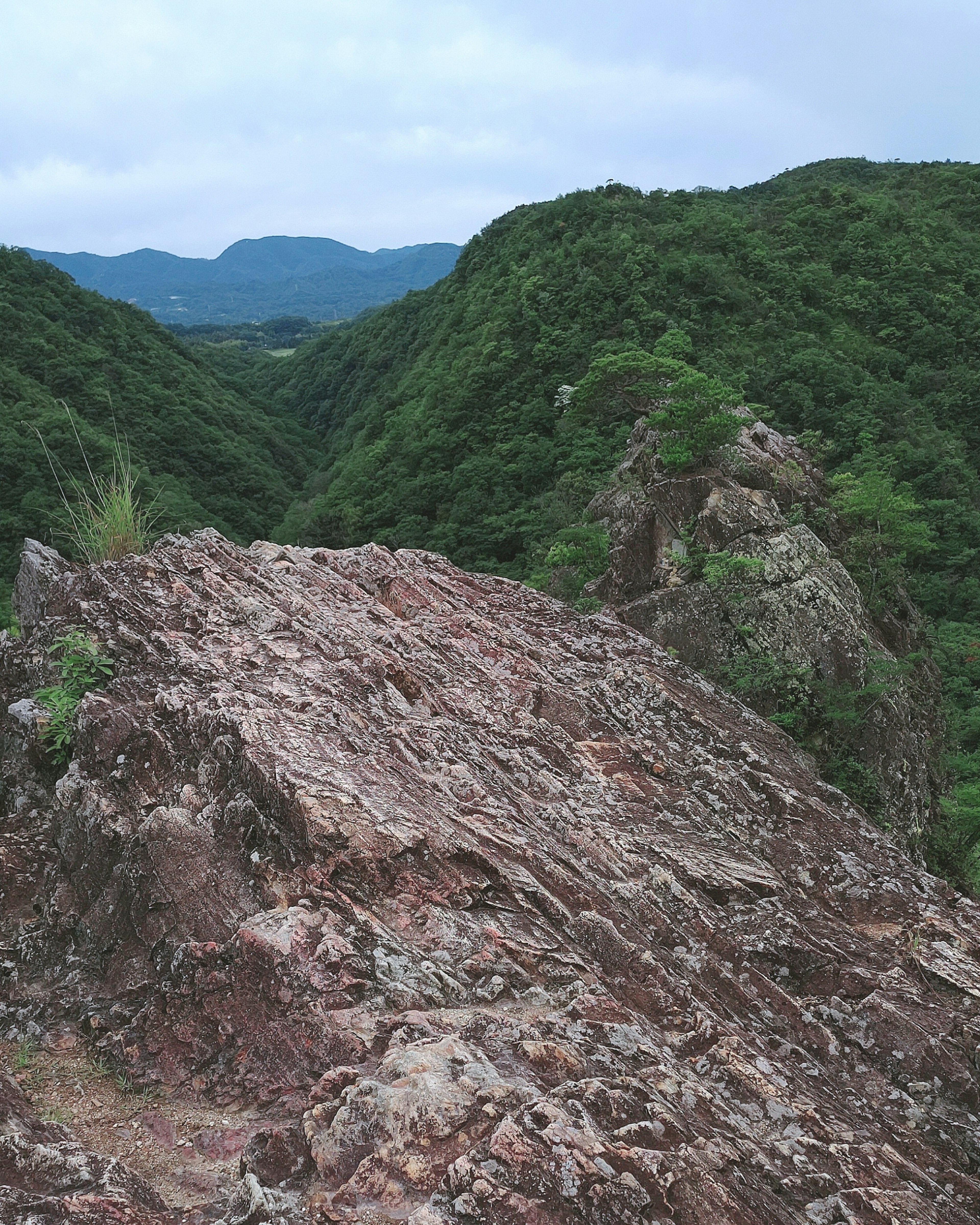 Rocky viewpoint surrounded by green mountains