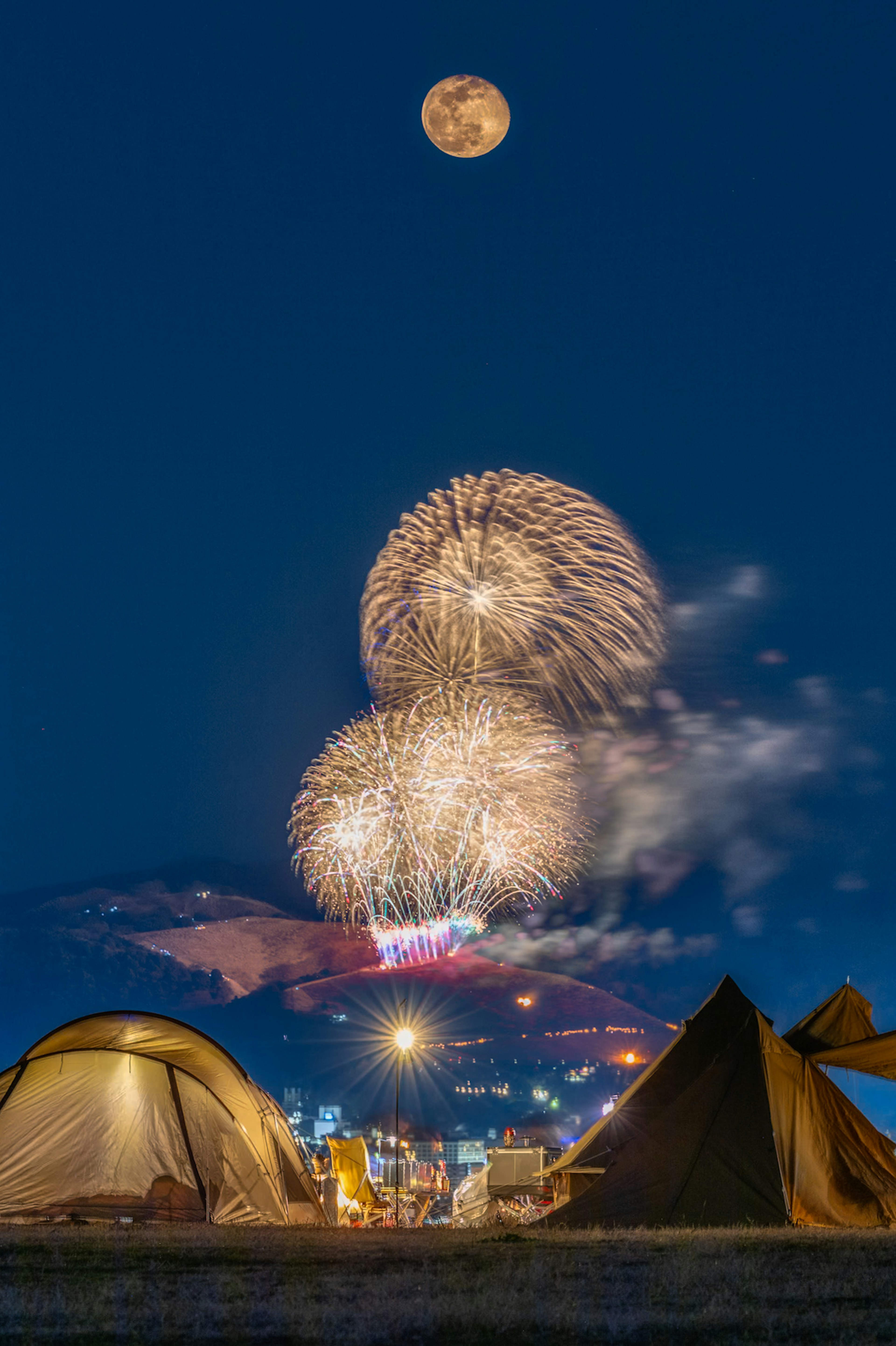 キャンプ場での花火と満月の夜空