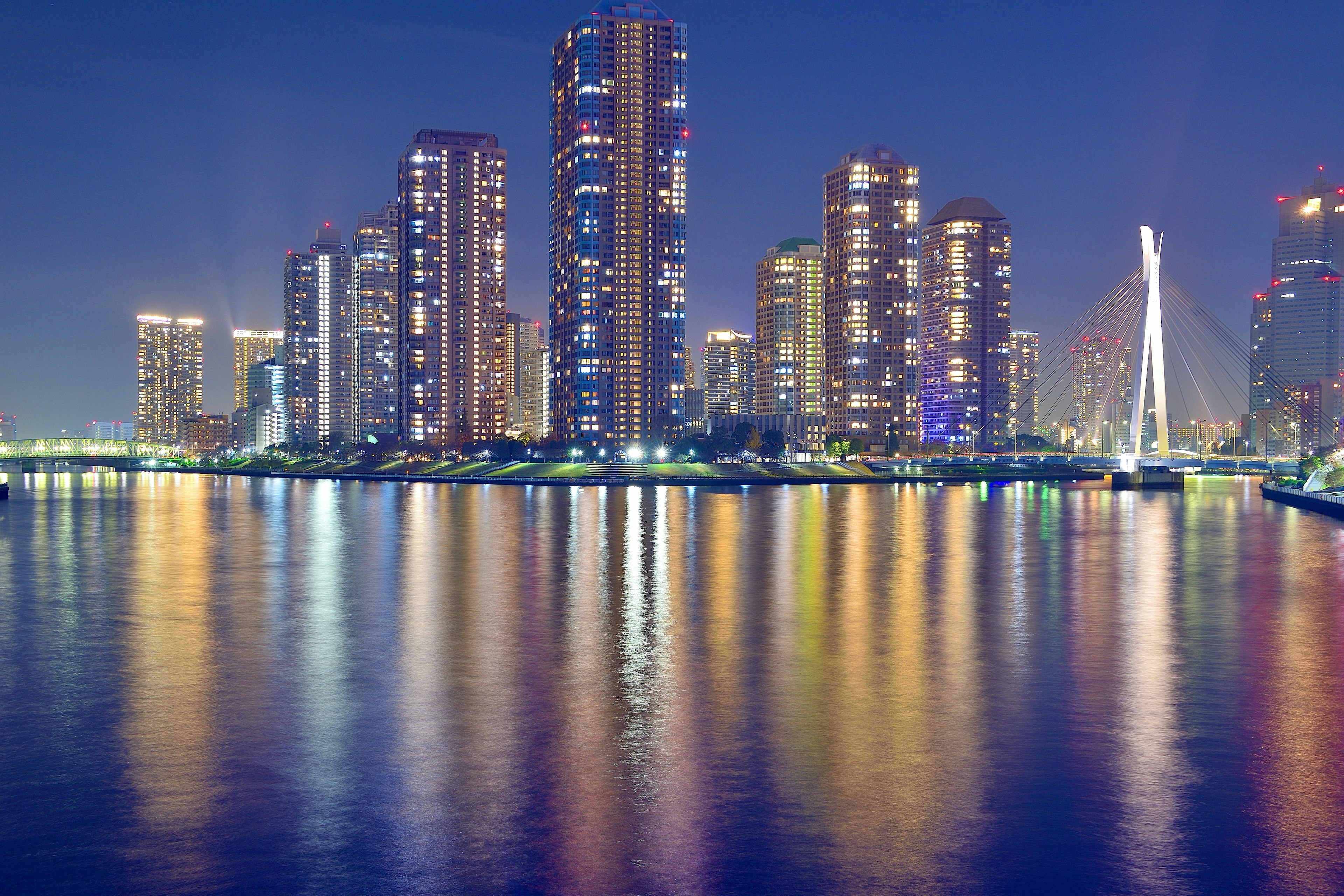 Paysage urbain nocturne avec gratte-ciels et reflets sur l'eau calme