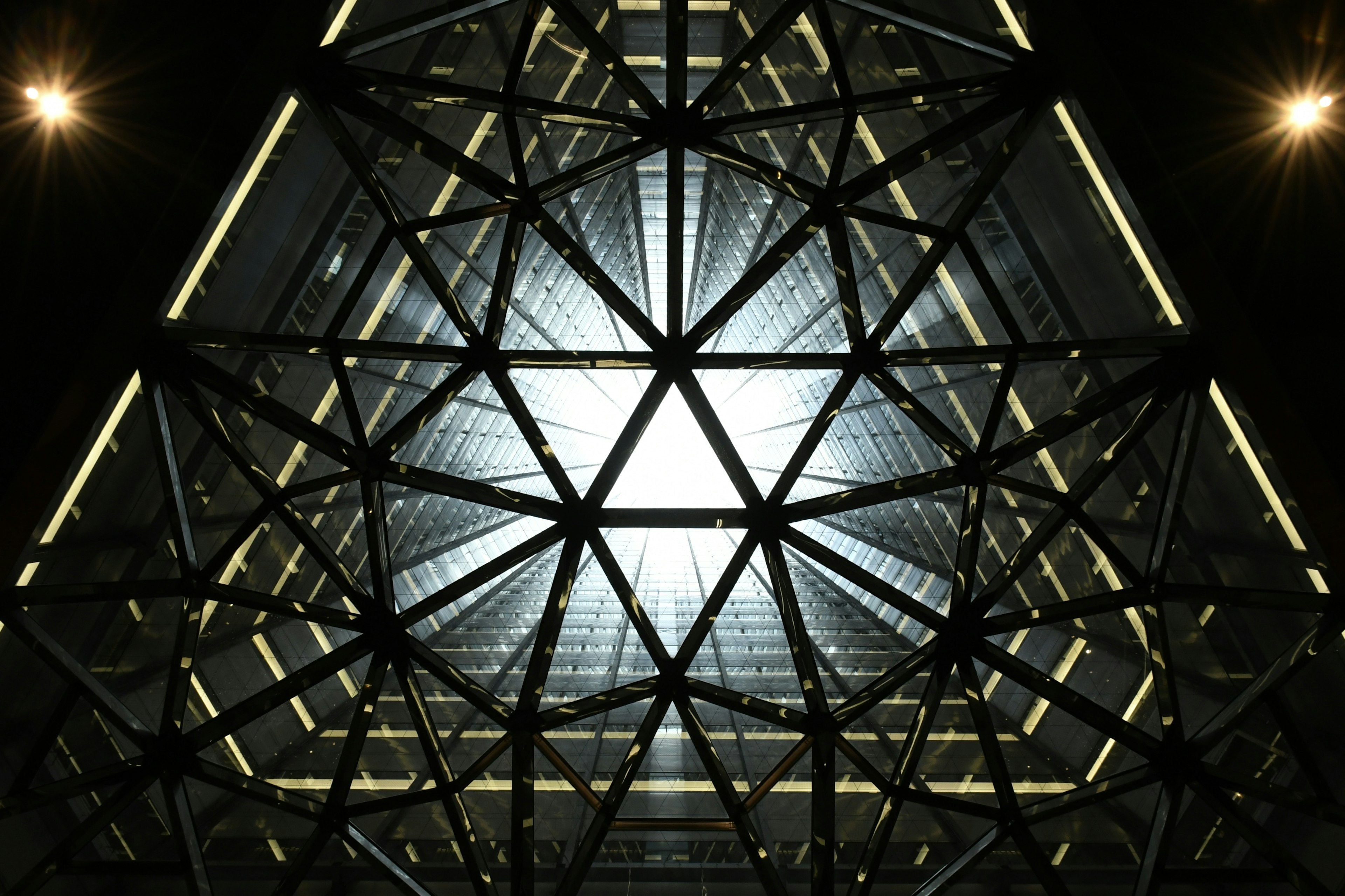 Vue intérieure d'un bâtiment moderne avec une structure triangulaire et de la lumière qui passe