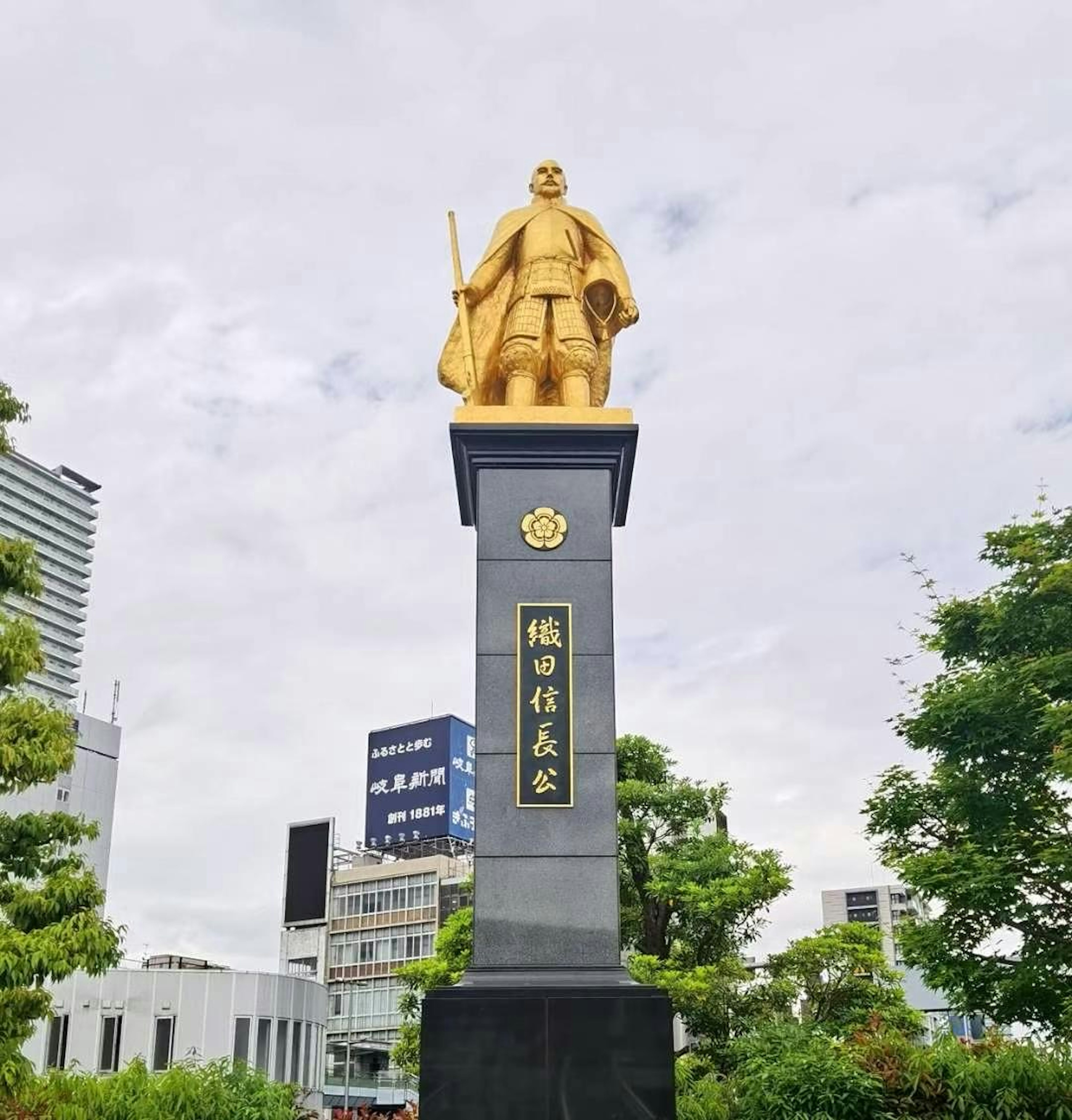 Golden statue of a samurai standing in a park