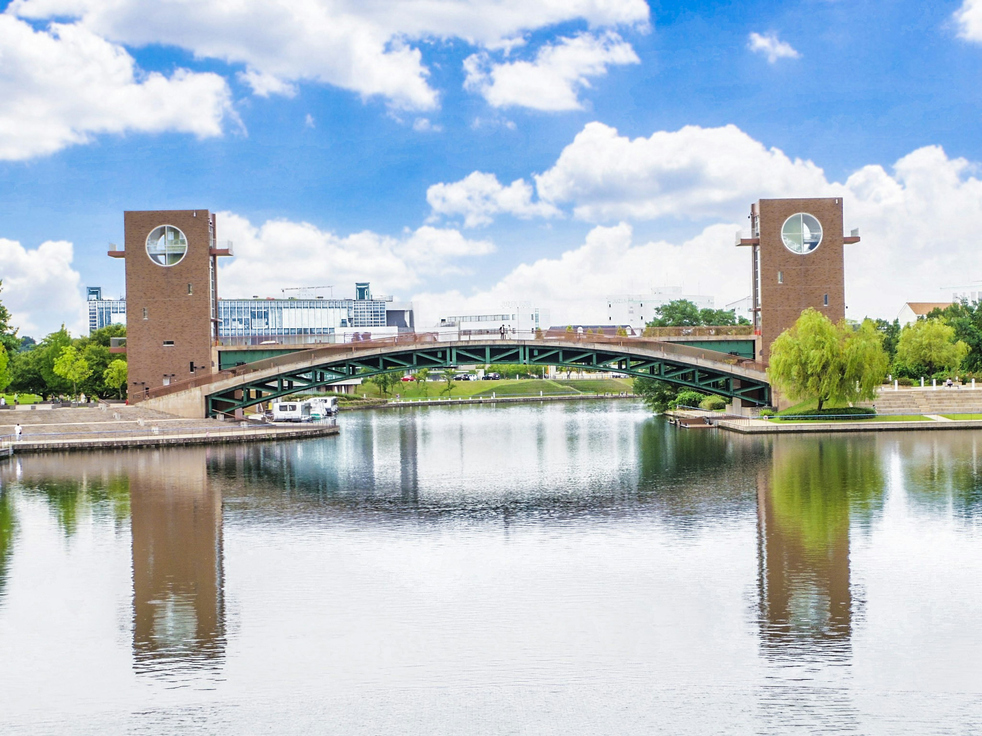 Eine Brücke mit Uhrentürmen, die sich unter einem blauen Himmel in einem See spiegeln