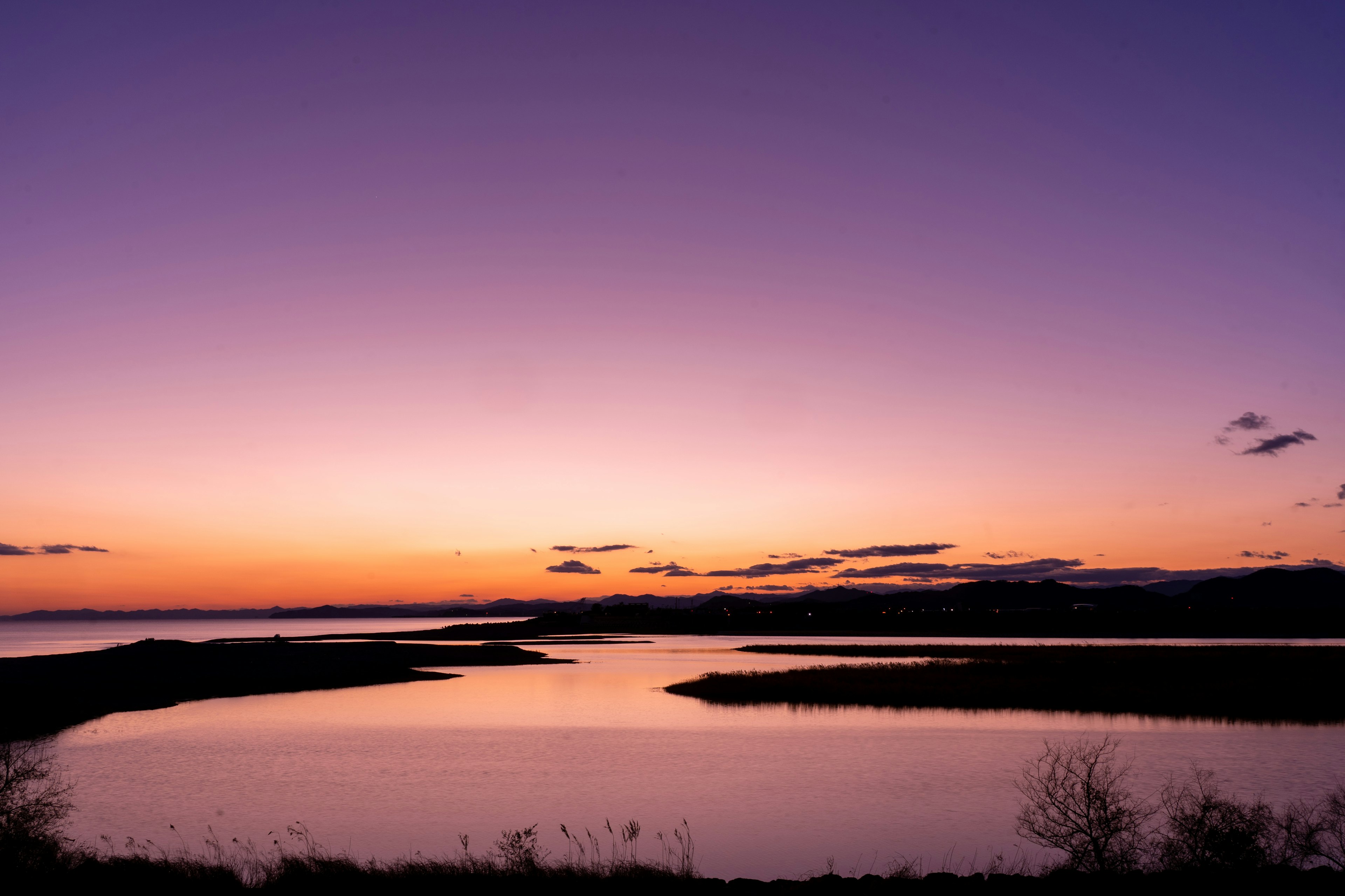 美しい夕焼けの風景、紫色の空と静かな水面が映る