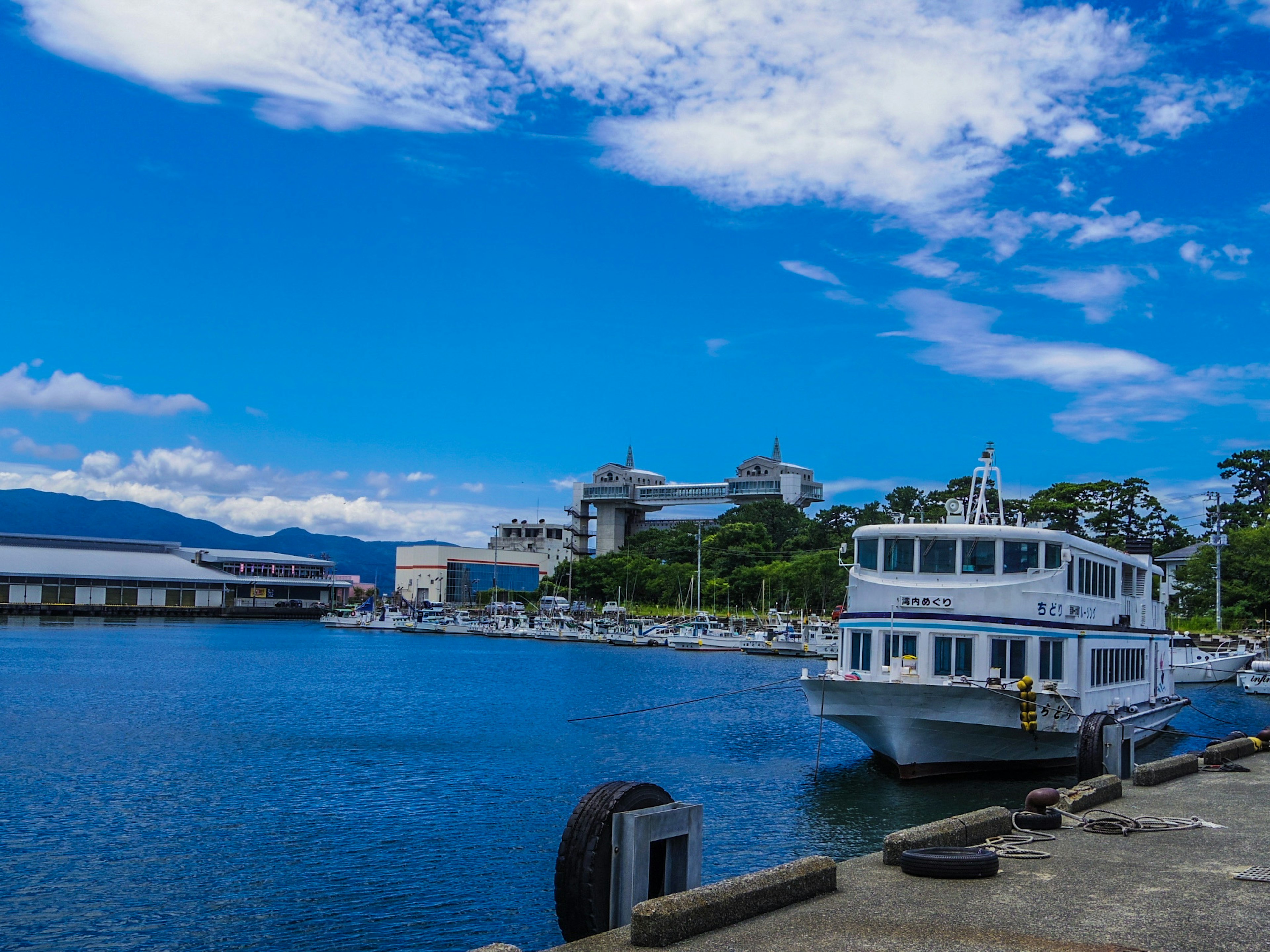 Un bateau blanc amarré dans un port sous un ciel bleu