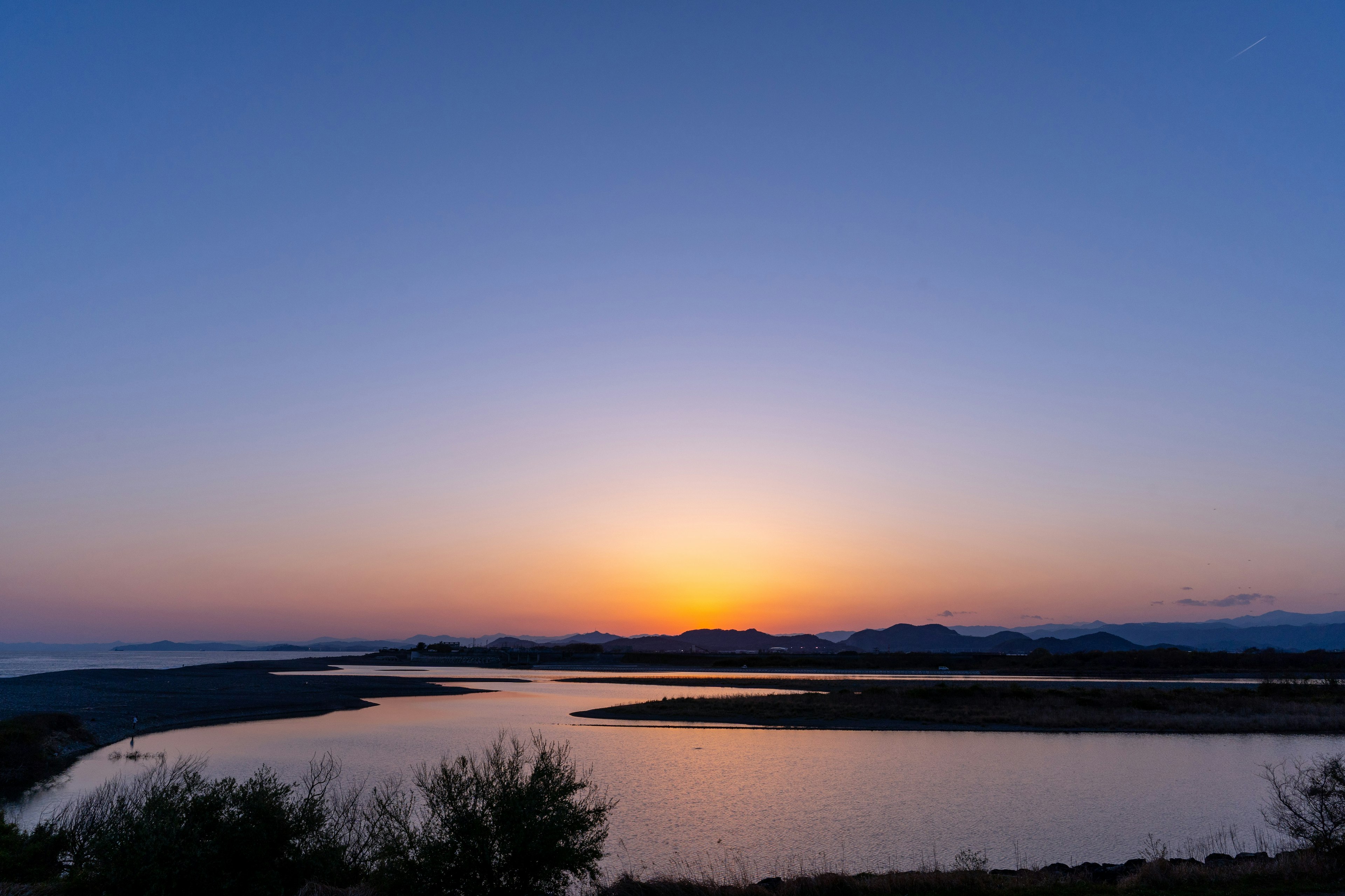 美しい夕焼けが映る川と山の風景