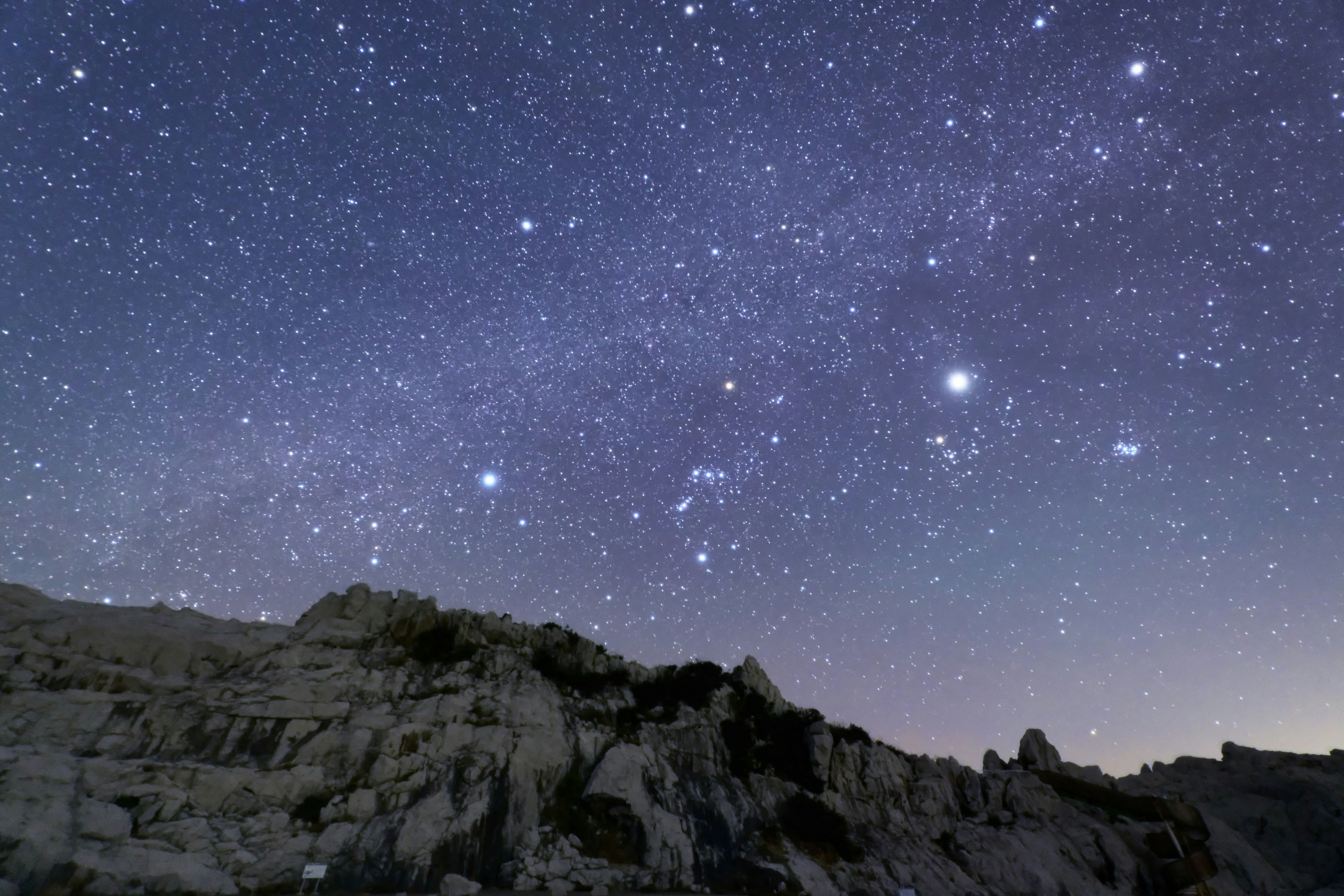 Pemandangan berbatu di bawah langit berbintang dengan bintang-bintang yang terlihat