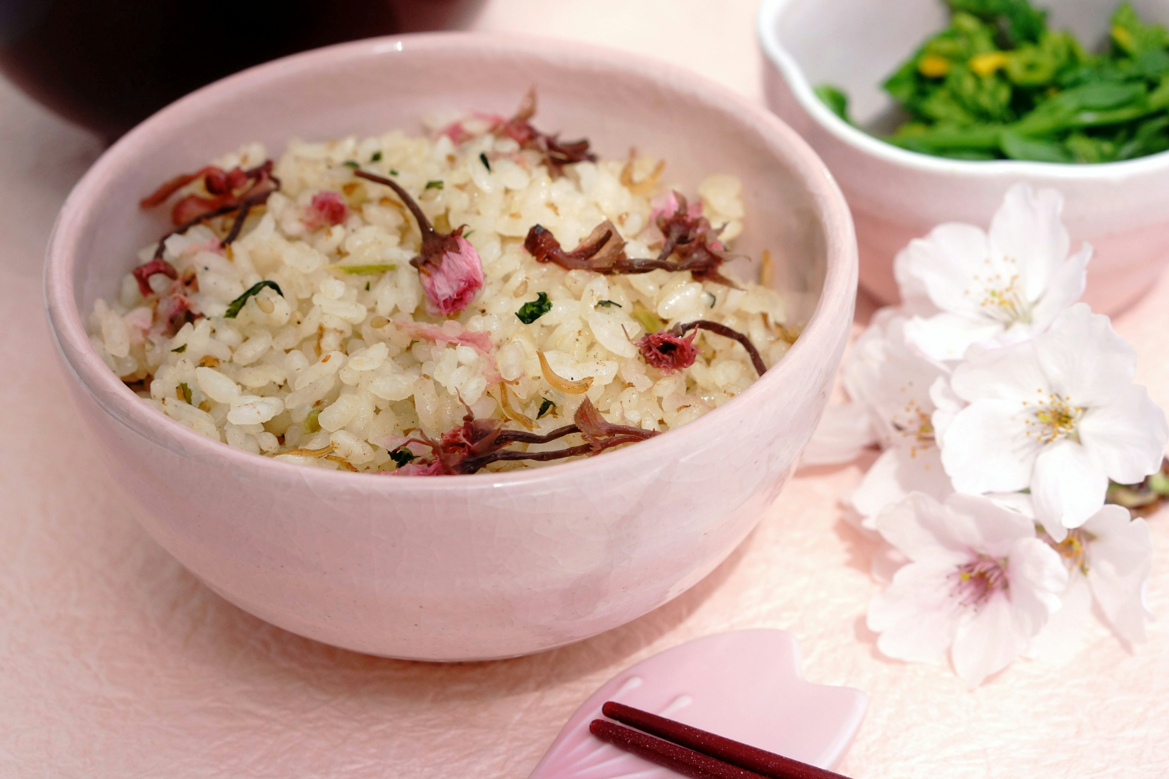 벚꽃이 얹힌 밥그릇과 초록 허브가 담긴 작은 접시