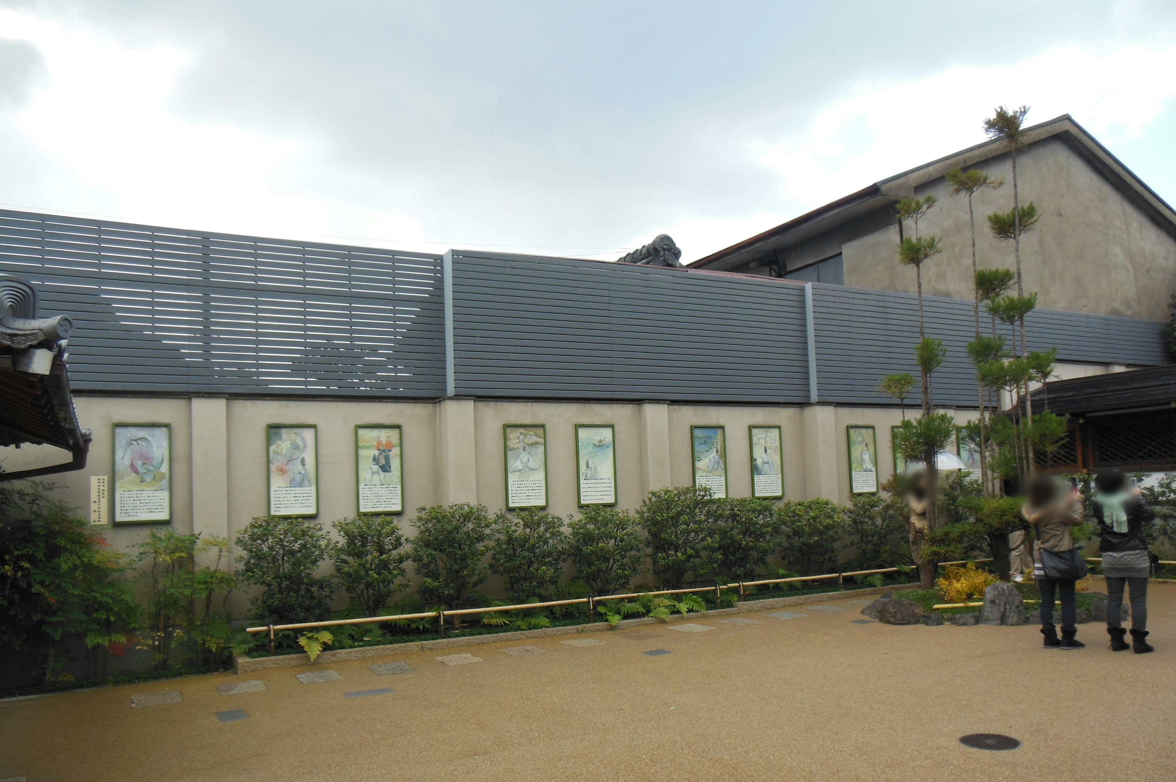 Exterior de un edificio moderno con obras de arte expuestas y plantas verdes