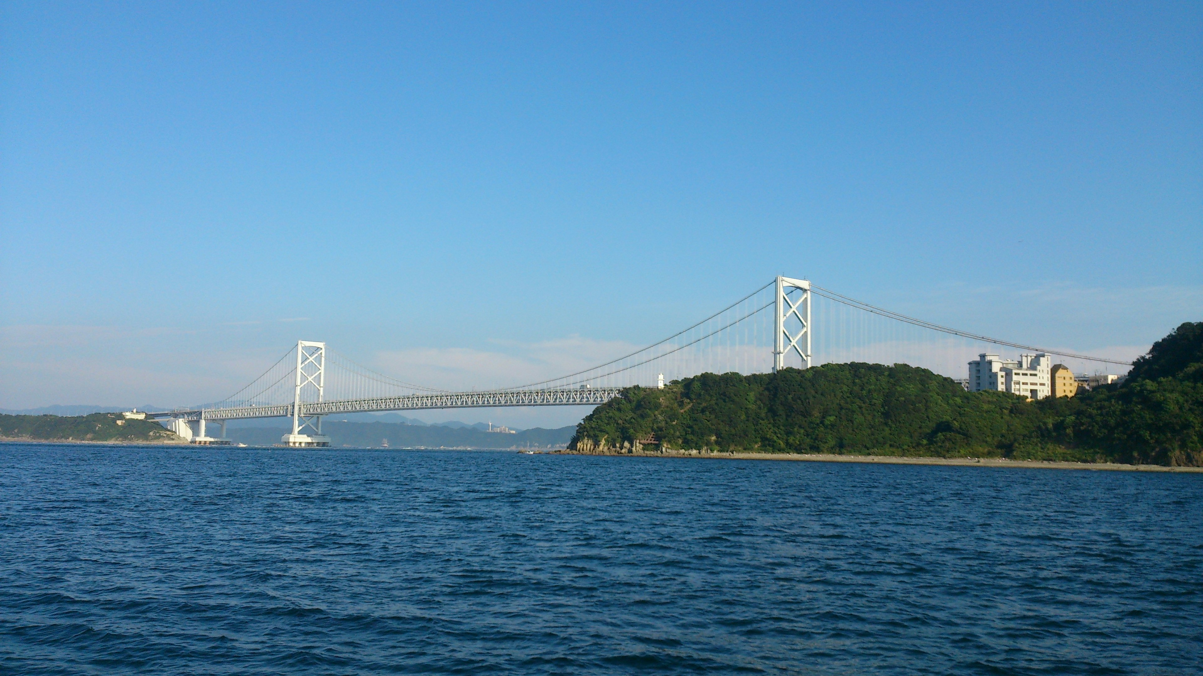 青い空の下に広がる海と橋が見える風景