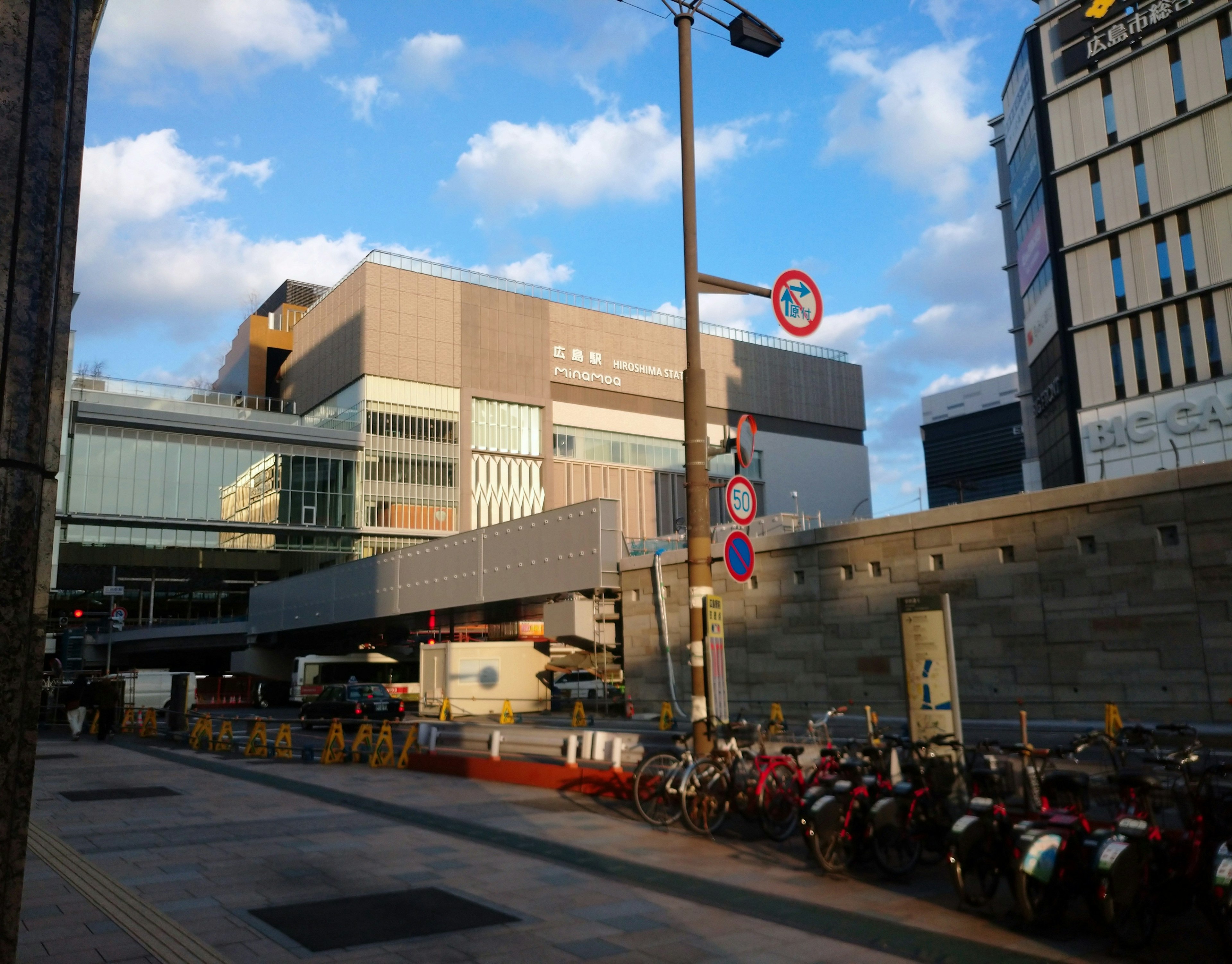 Modern station building with parked bicycles and street signs