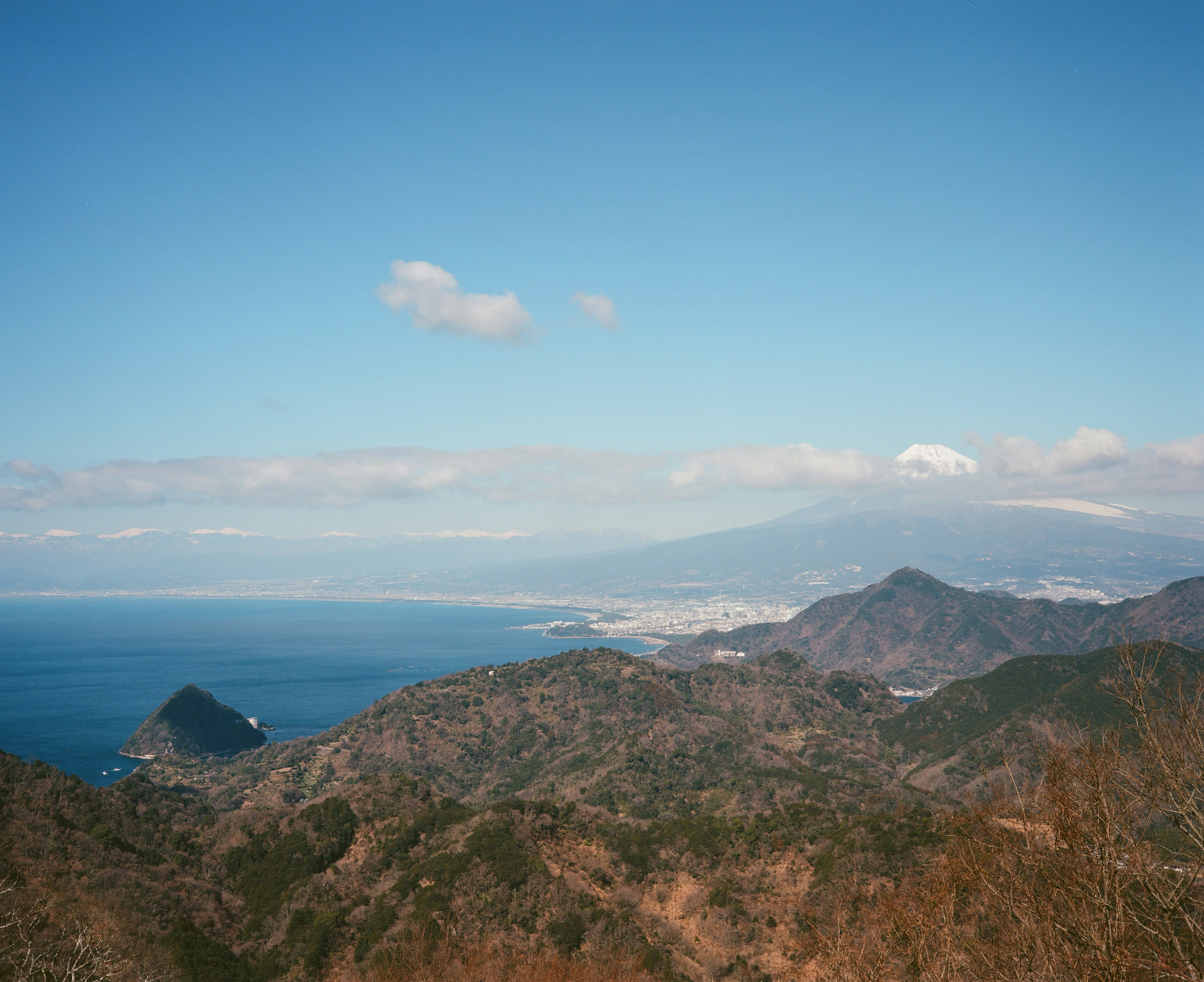 青空の下に広がる山と海のパノラマ風景