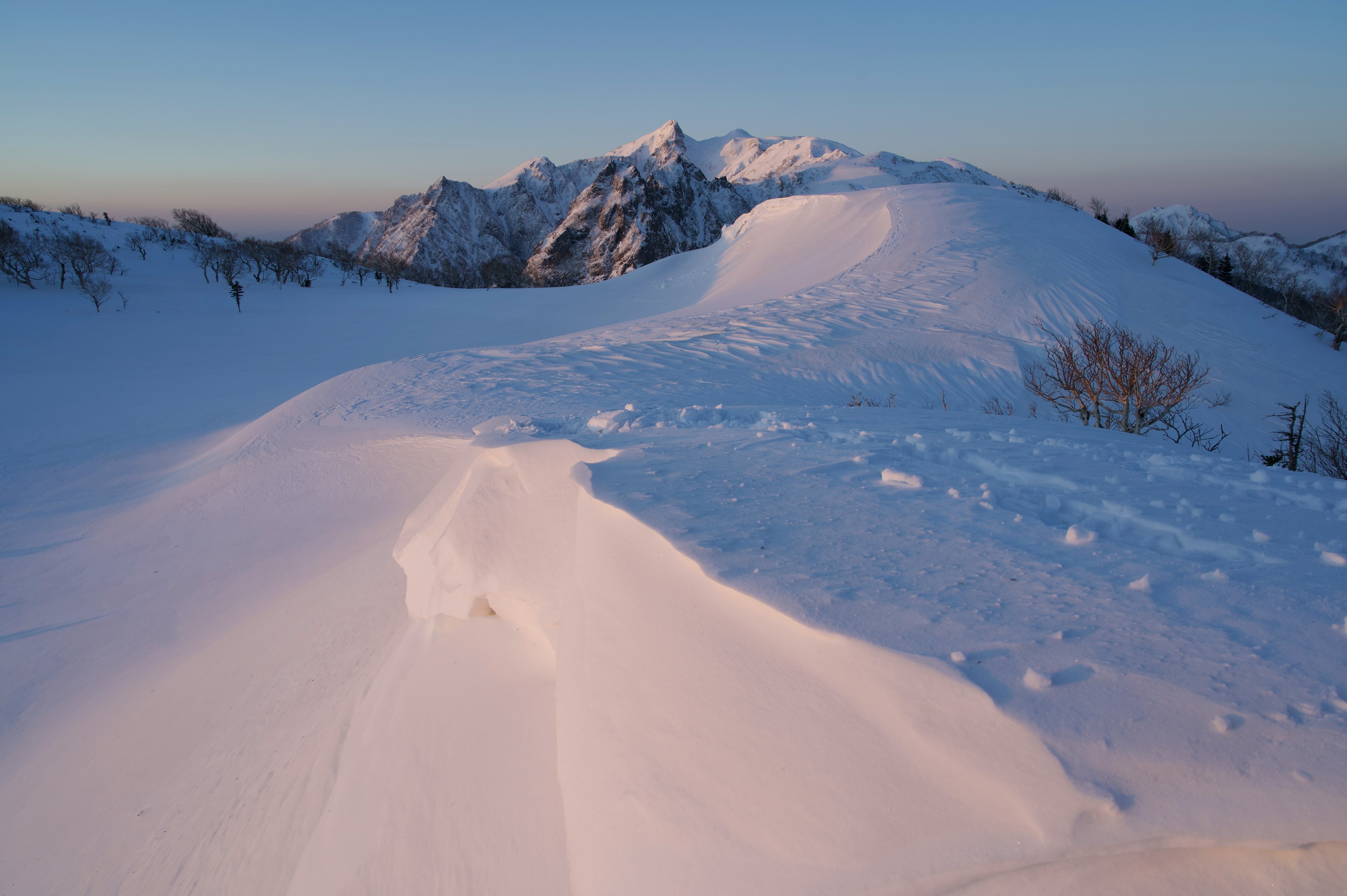 Snow-covered mountain landscape with a clear blue sky