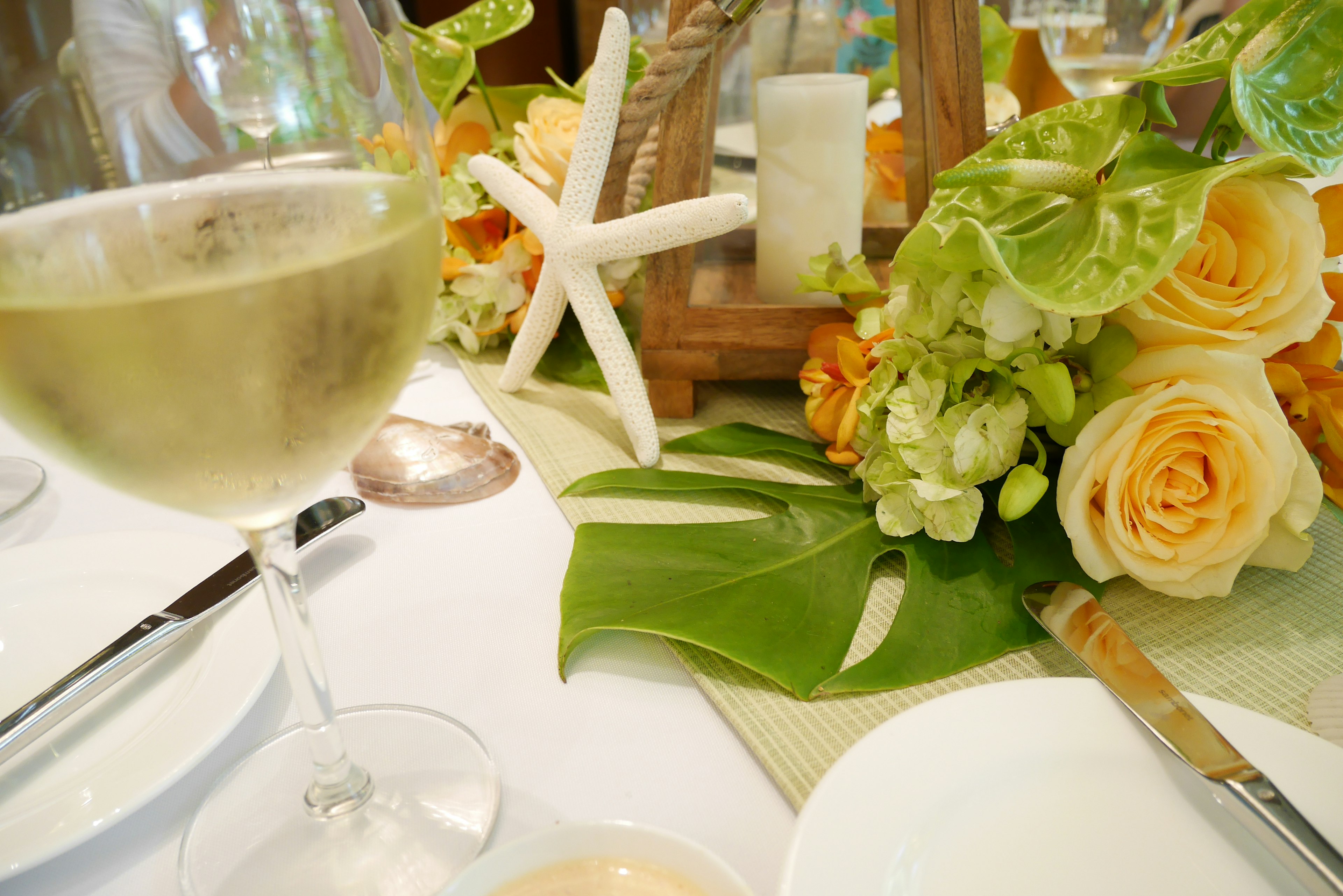 Table setting with white wine and floral arrangement