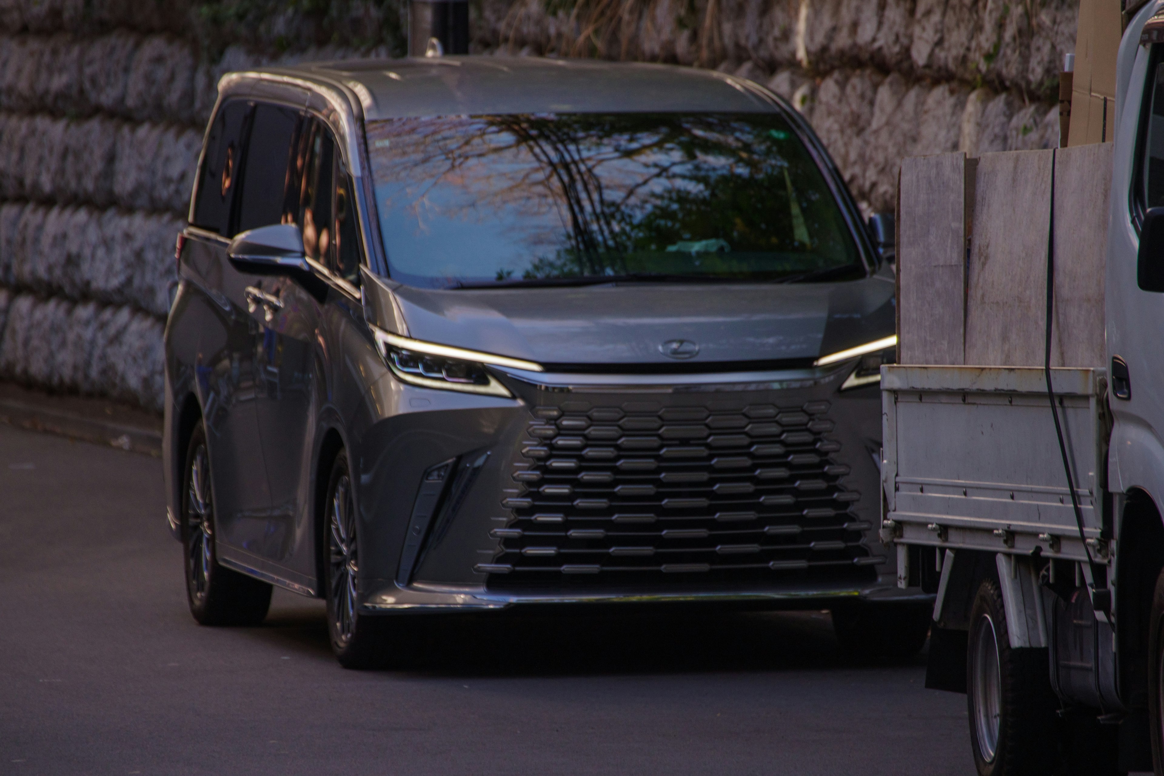 Gray minivan driving on a city street