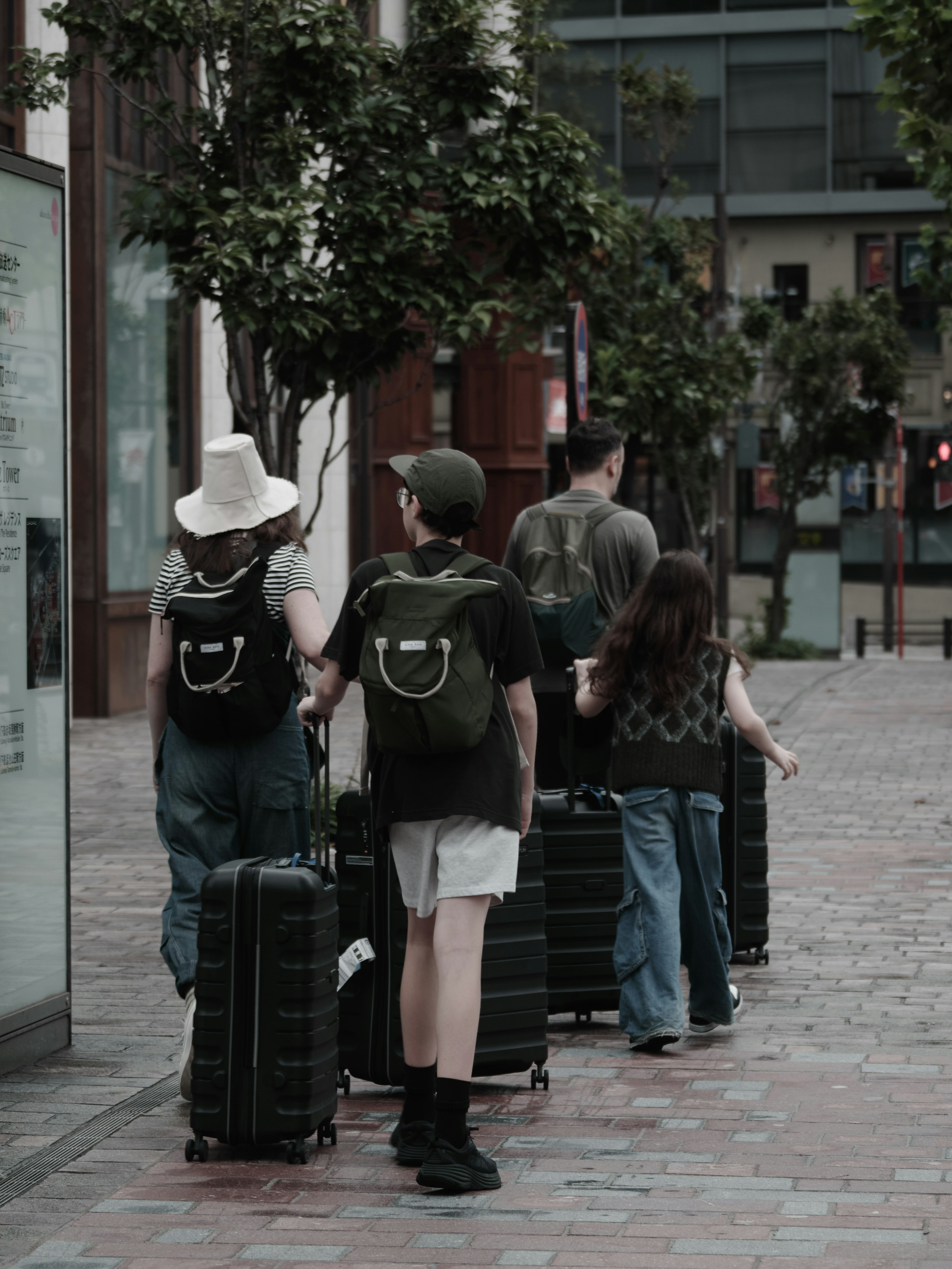 Familia caminando por la calle con maletas