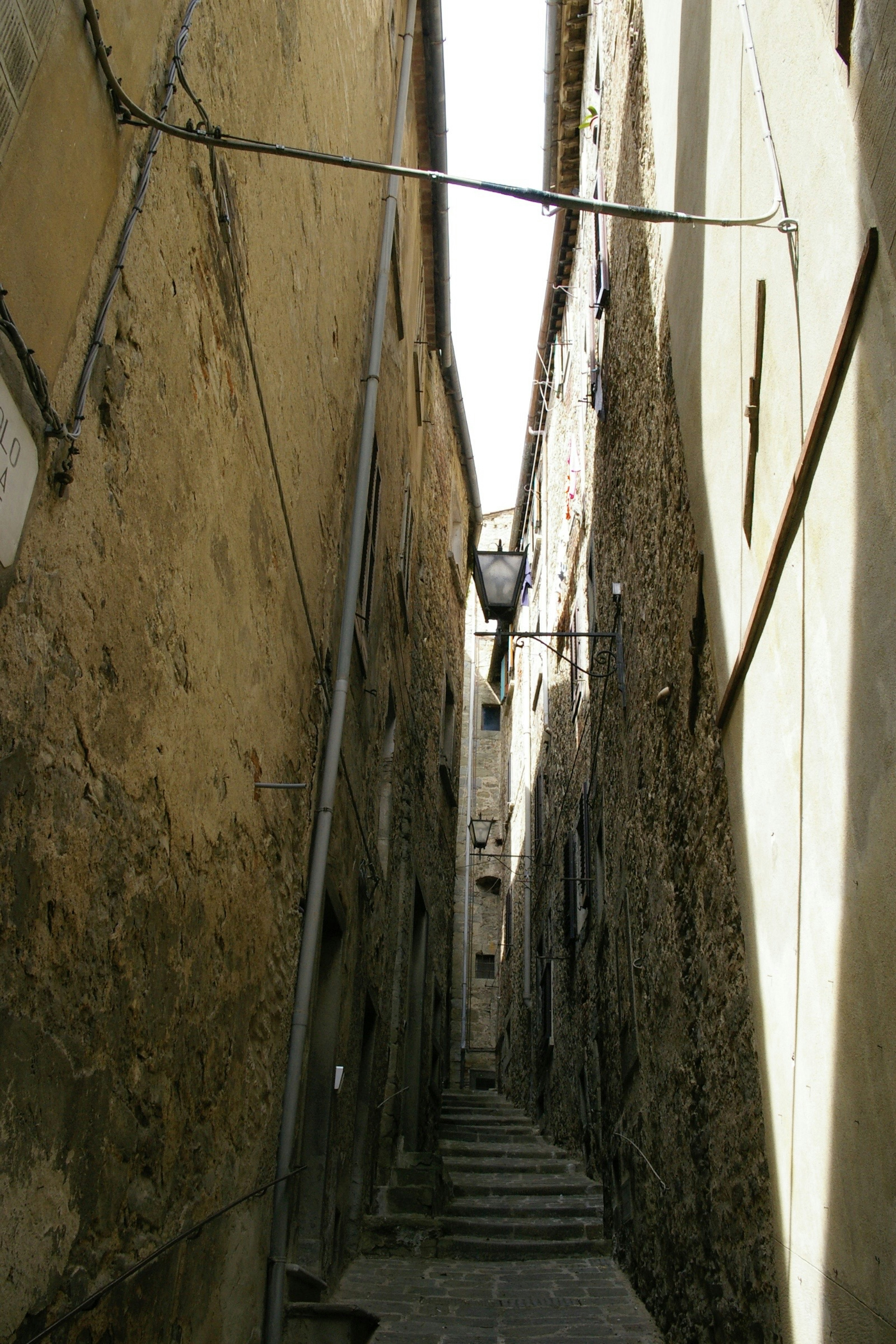 Narrow cobblestone alley flanked by old buildings