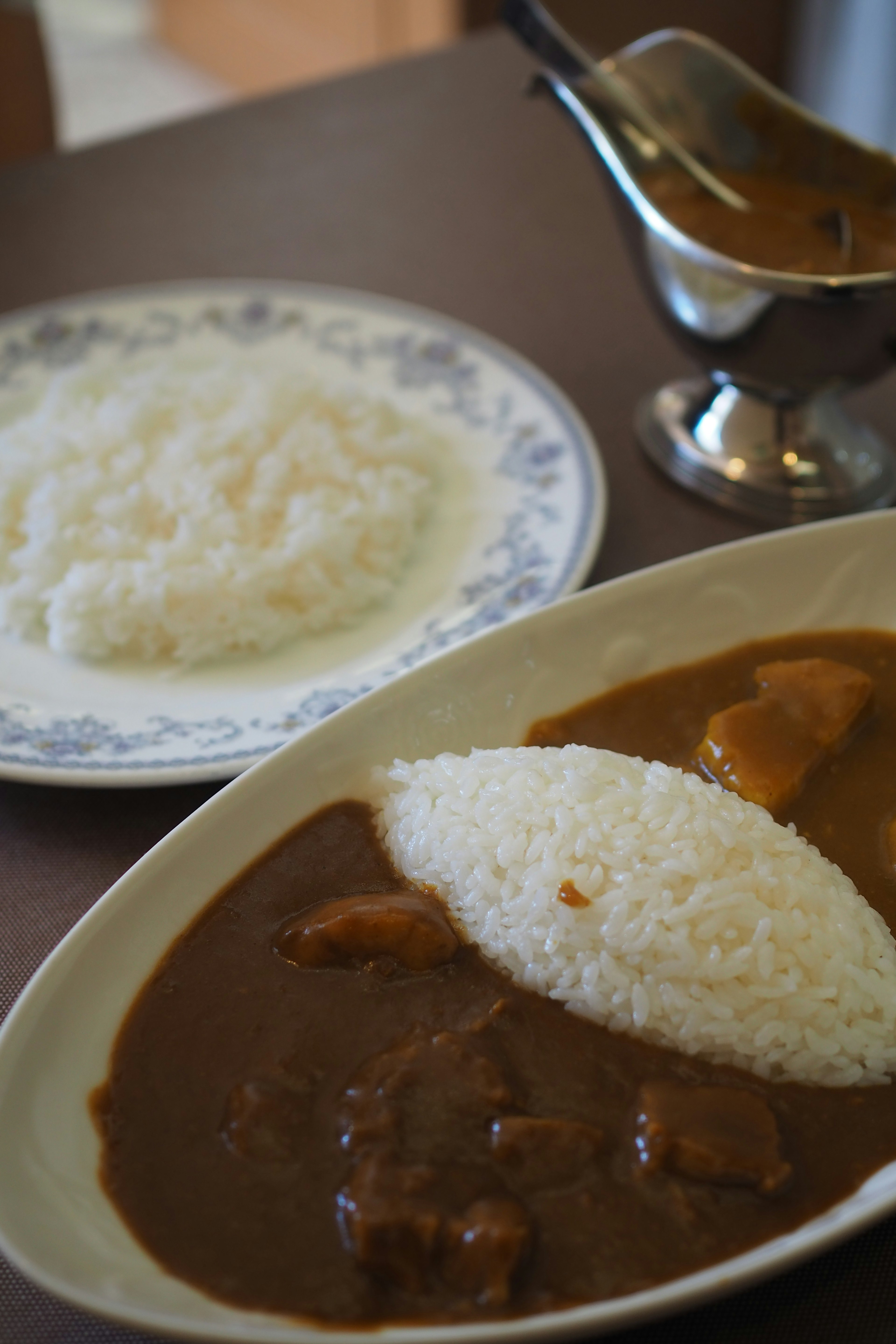 A plate of curry rice featuring a mound of rice and curry ingredients