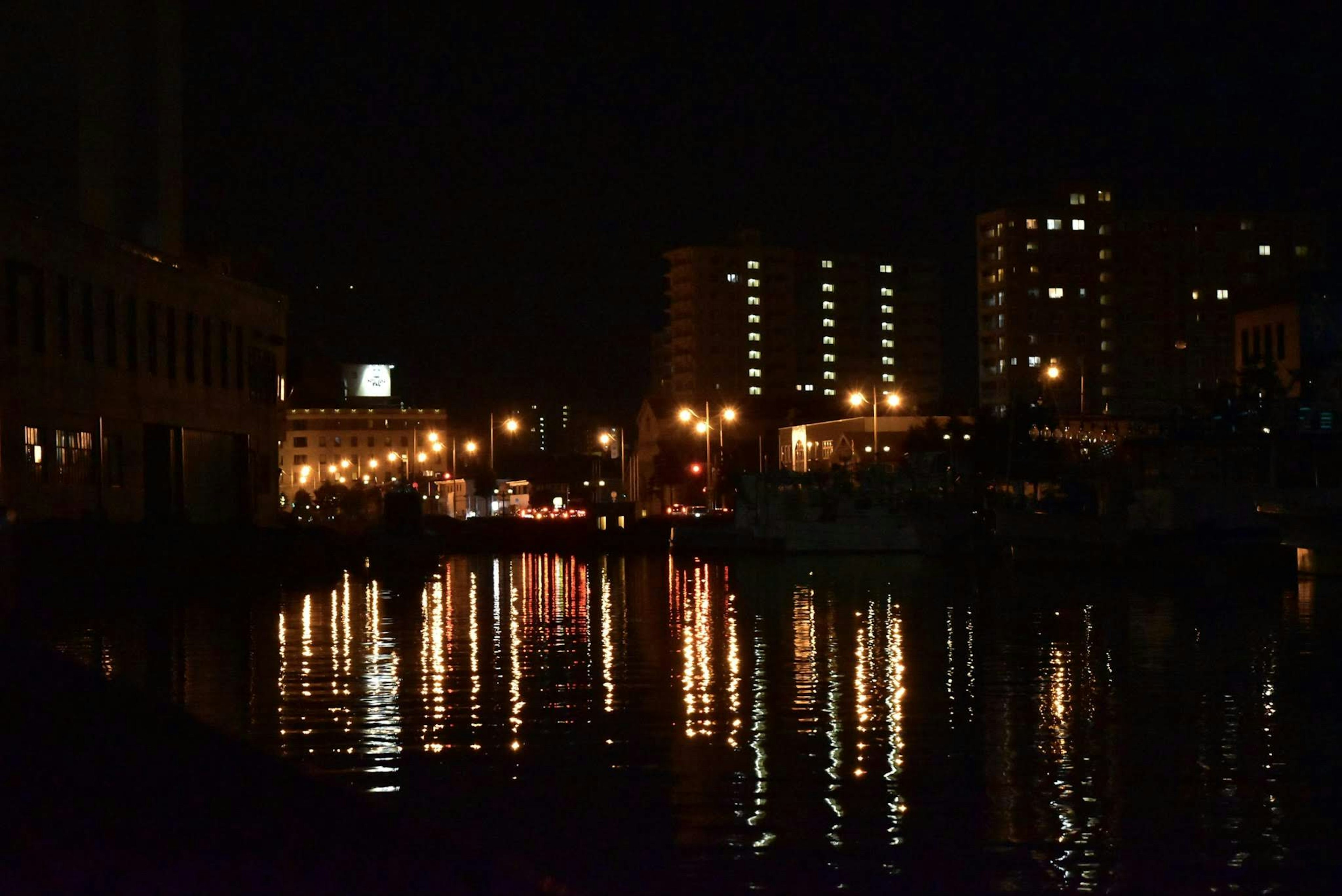 Nächtliche Stadtlandschaft mit Lichtreflexionen auf dem Wasser