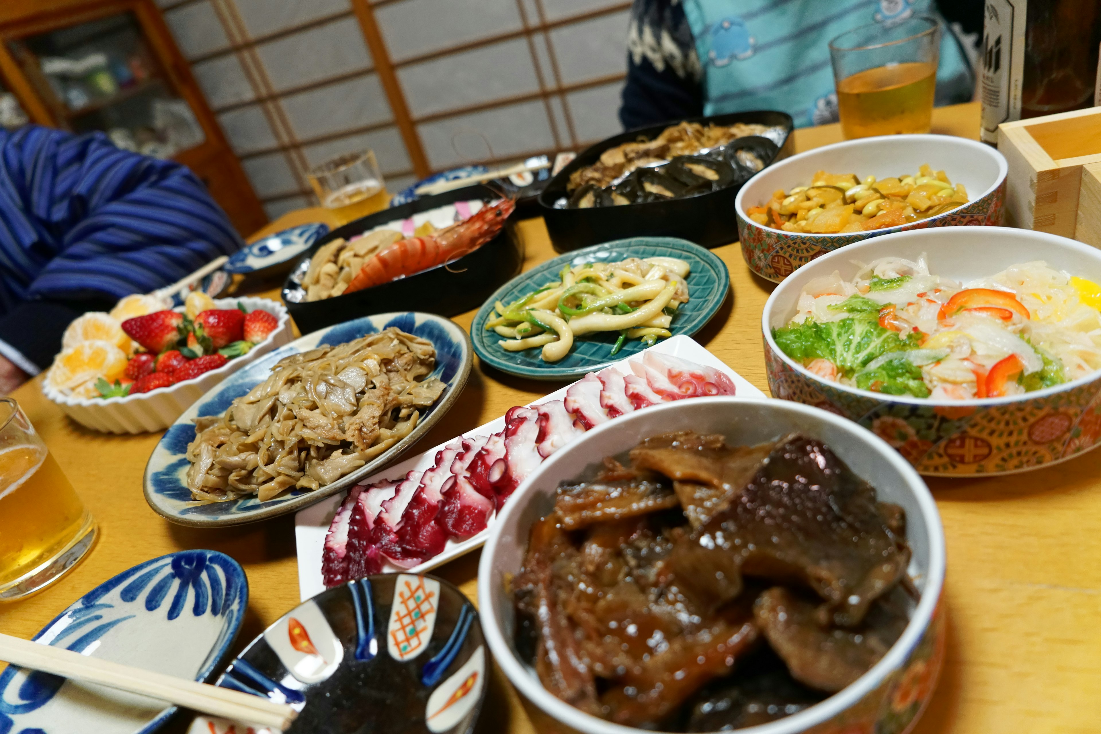 A table spread with various colorful Japanese dishes