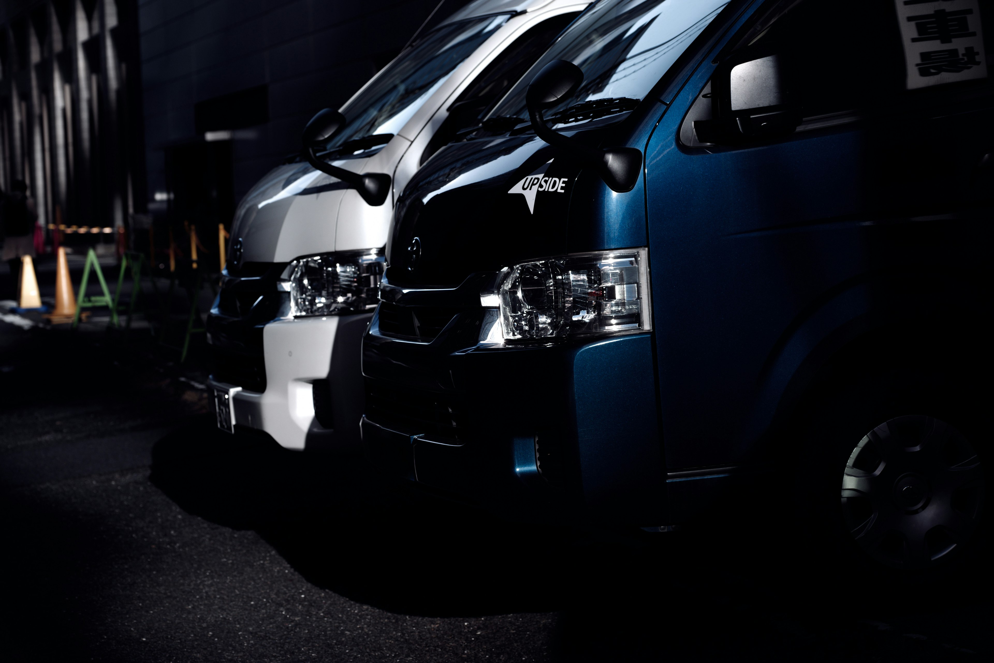 White and blue vans parked in a dark setting