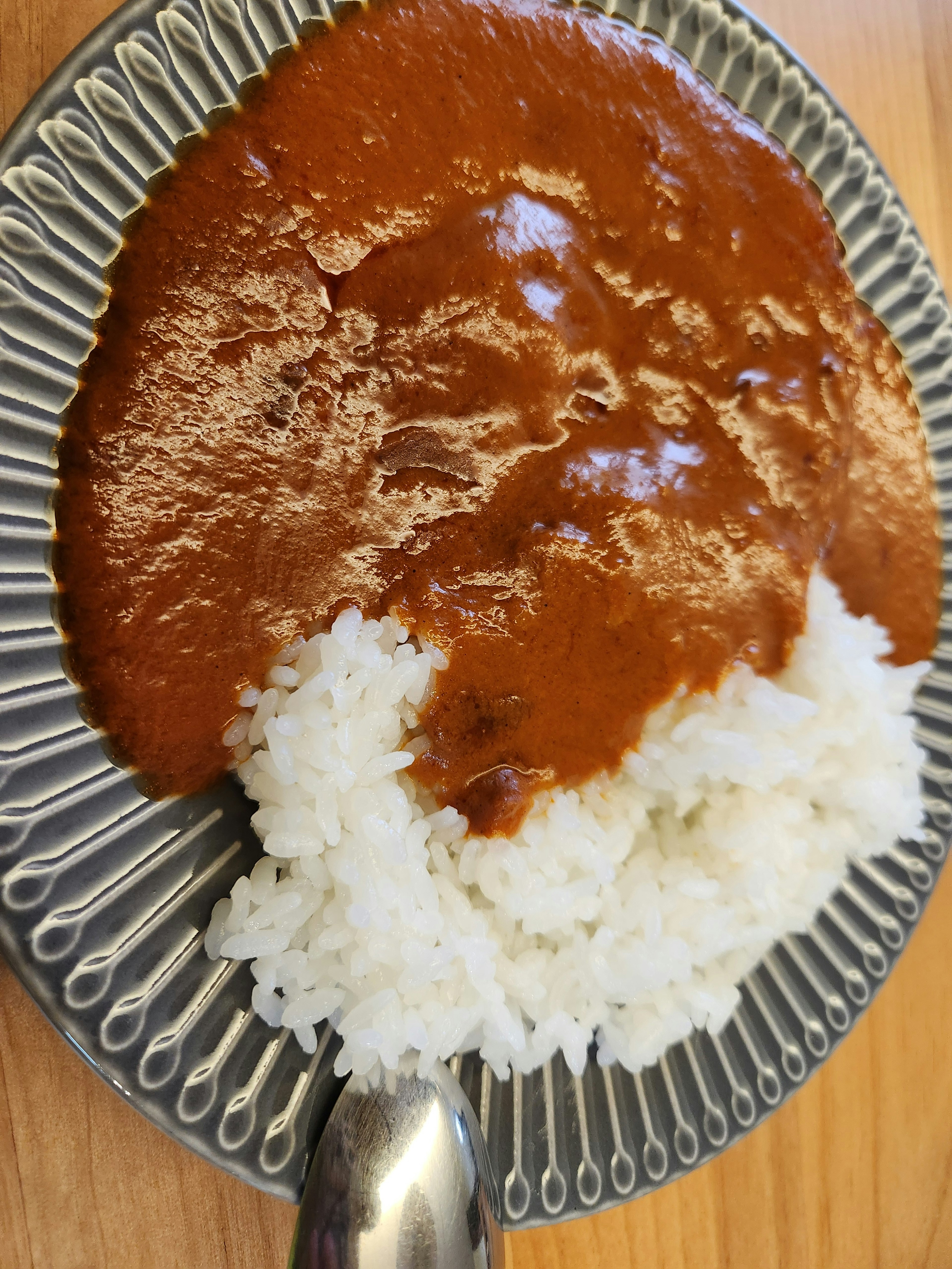 Sauce curry riche versée sur du riz blanc