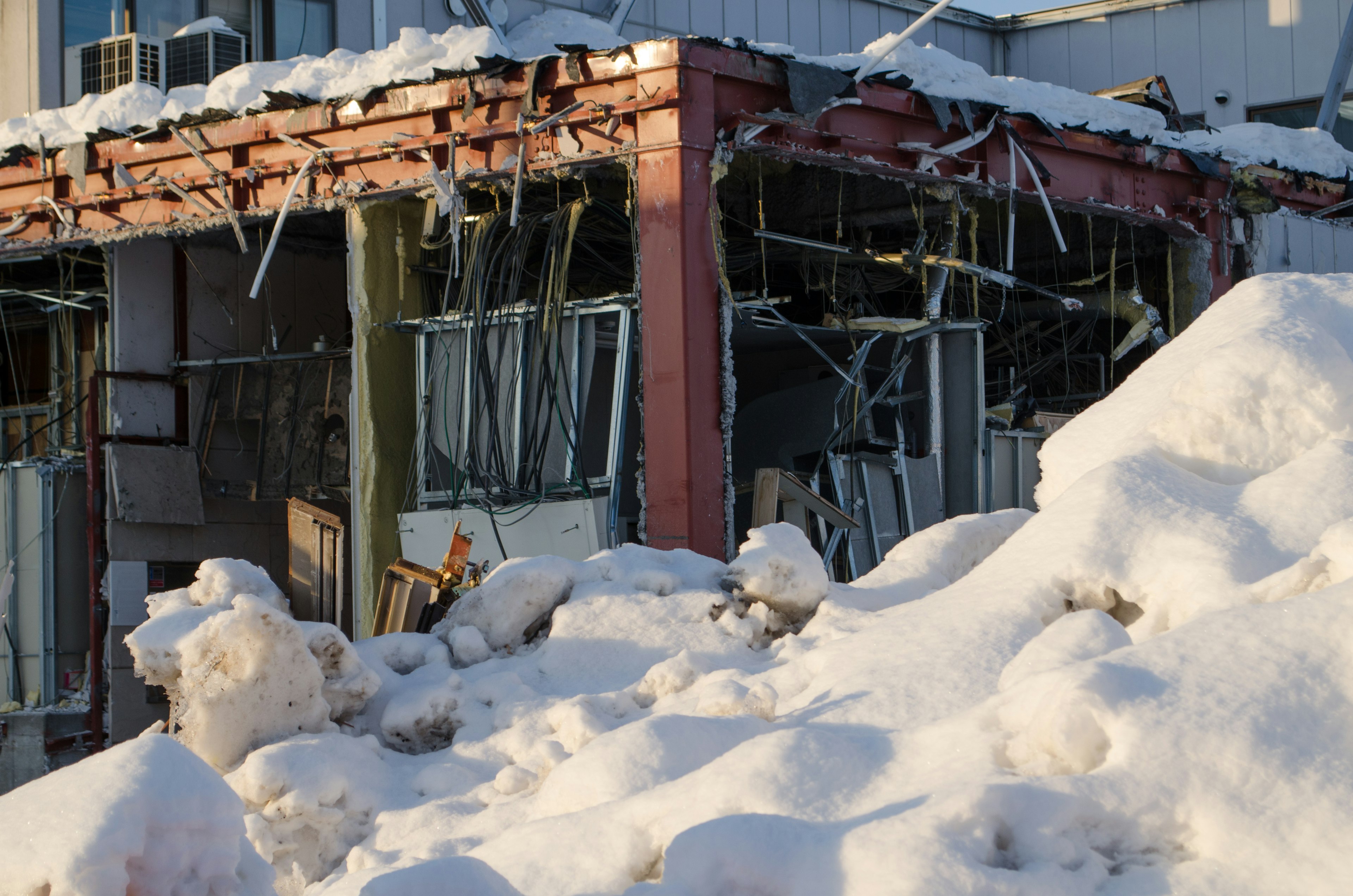 Edificio en ruinas cubierto de nieve con ventanas rotas