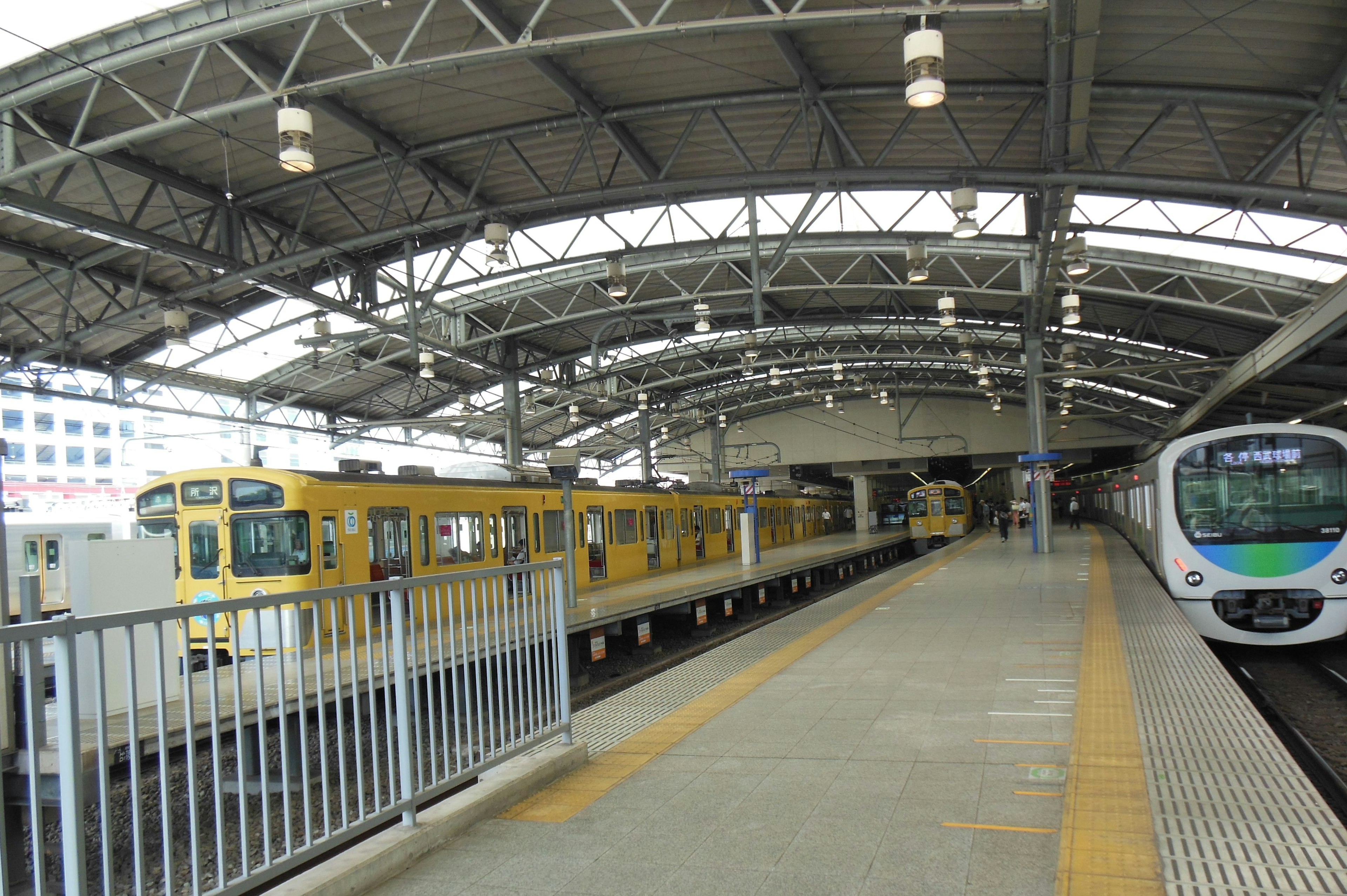 Train station platform with parked trains and roof structure