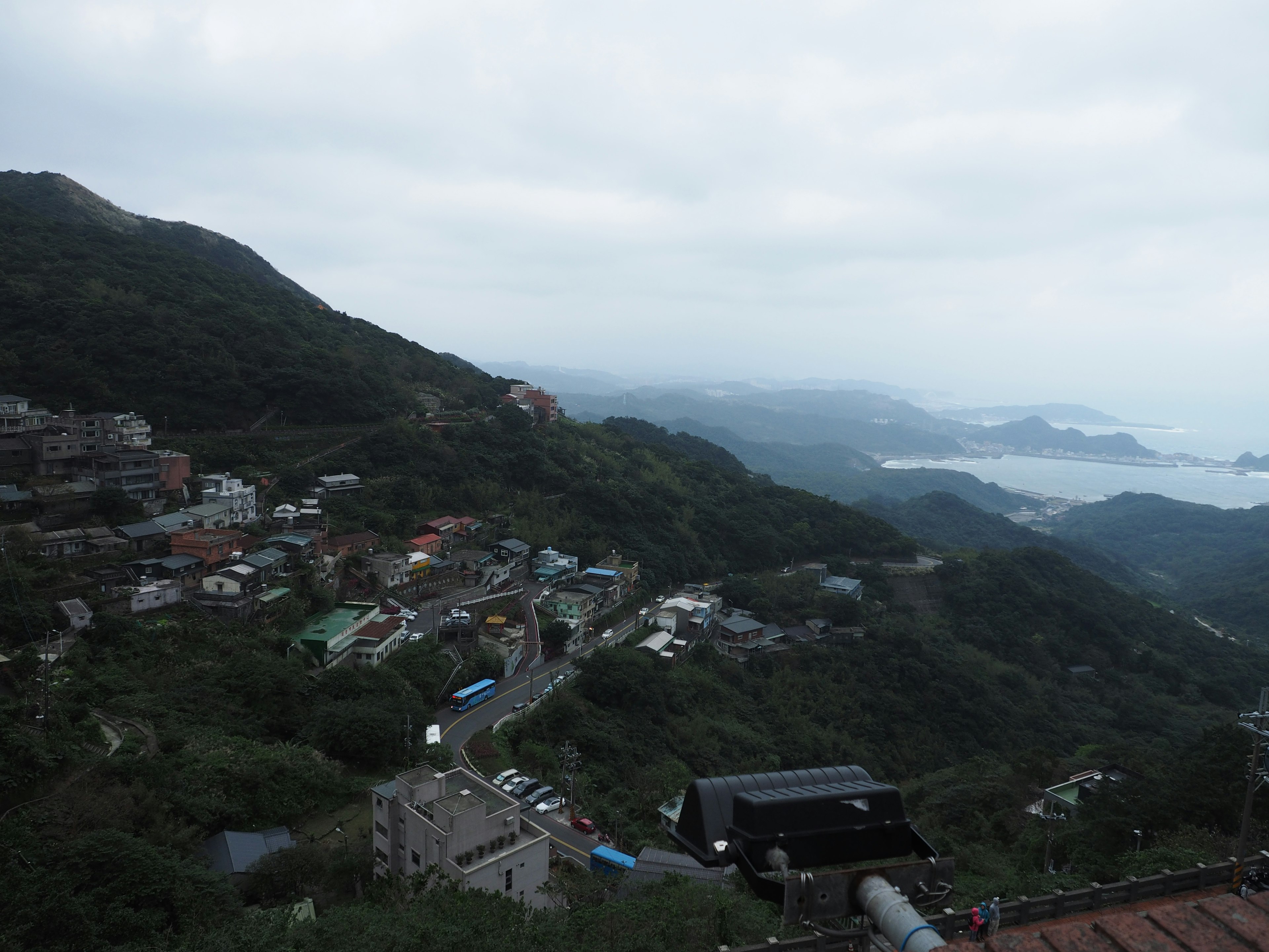 Vue nuageuse sur un paysage montagneux avec des maisons dispersées