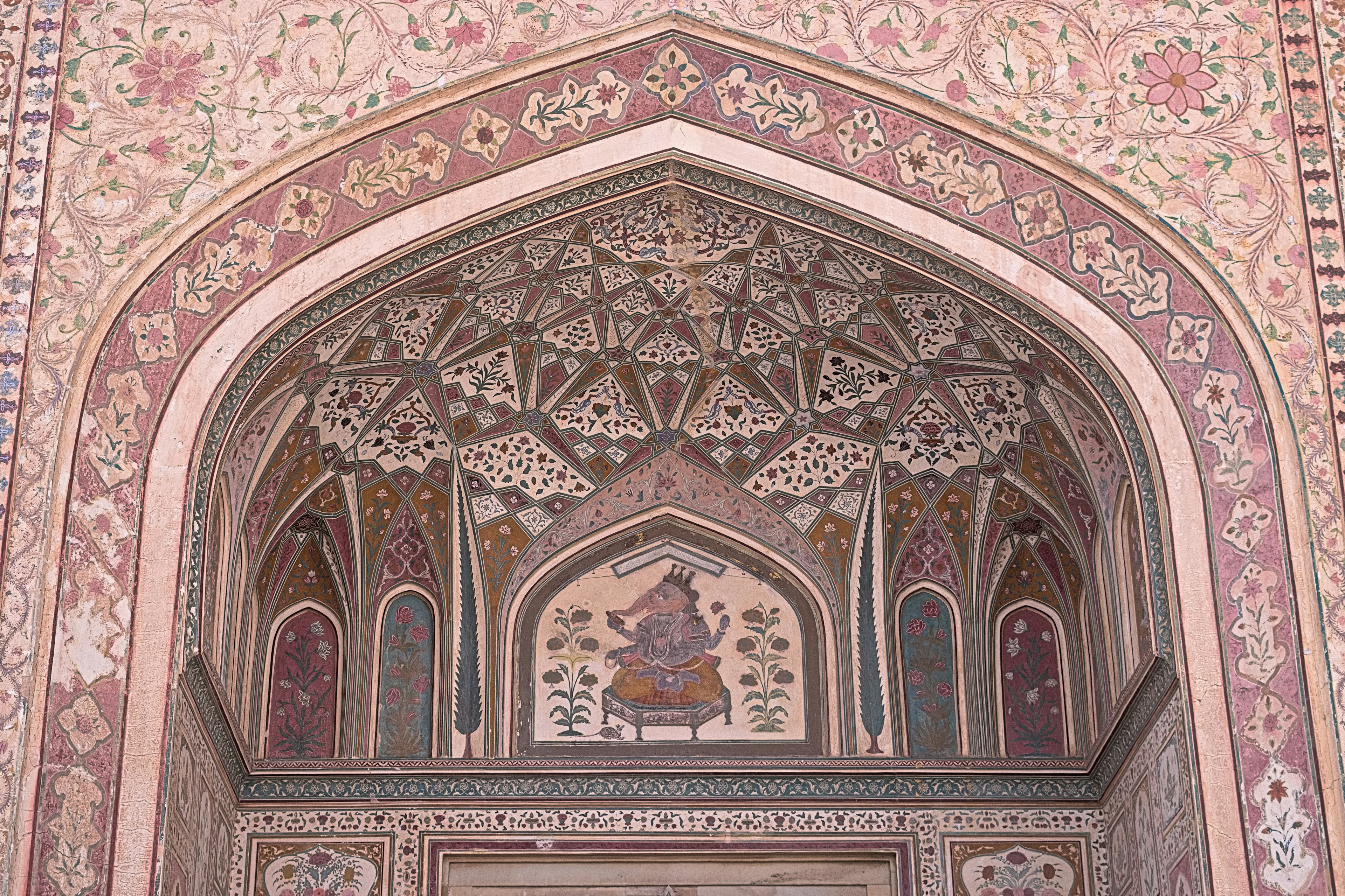 Beautifully decorated arch with intricate ceiling patterns and wall art