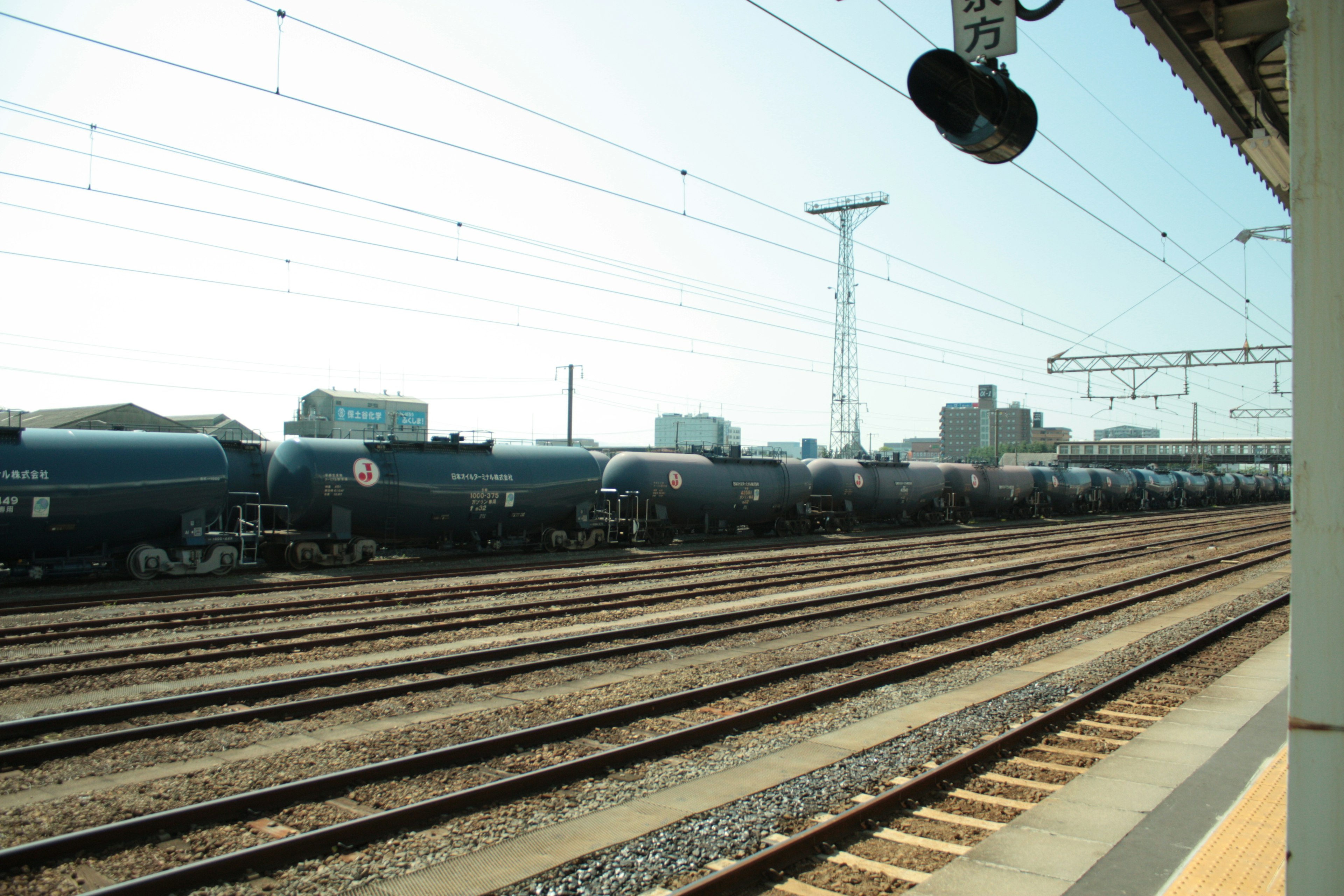 青い貨物列車が並ぶ鉄道の風景