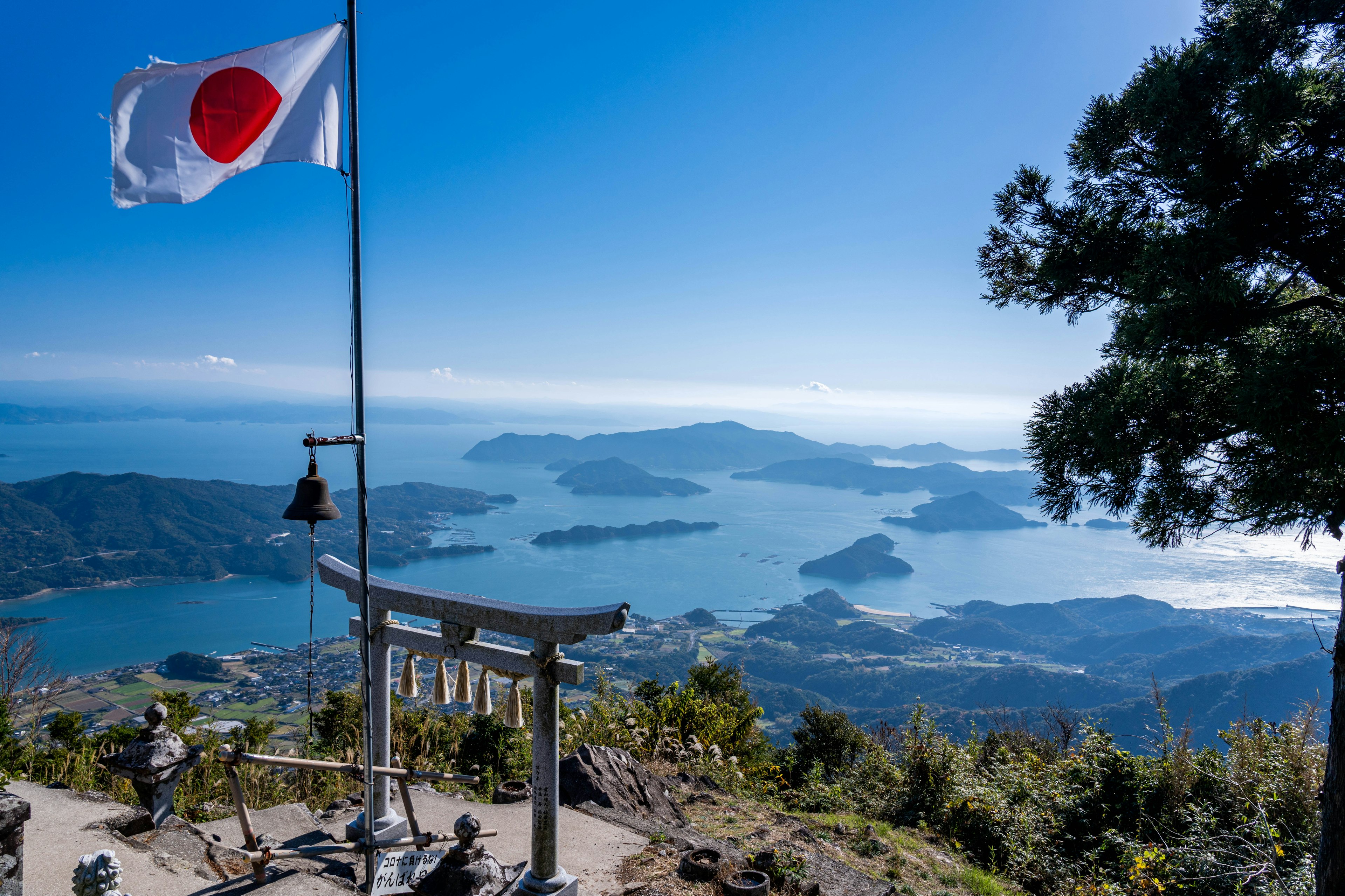 Khung cảnh đẹp với cờ Nhật Bản và cổng torii nhìn ra đại dương