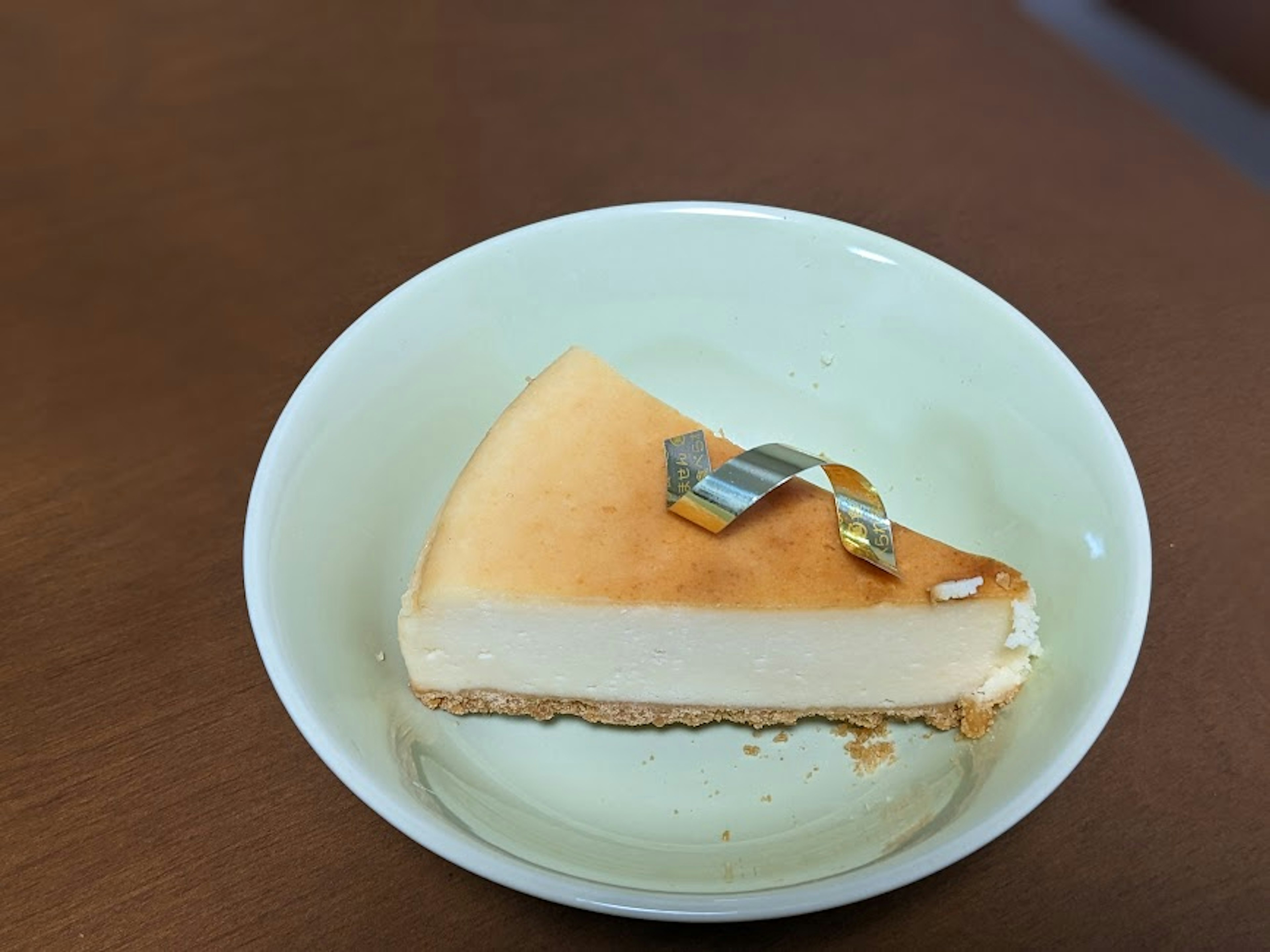 A slice of creamy cheesecake on a light green plate