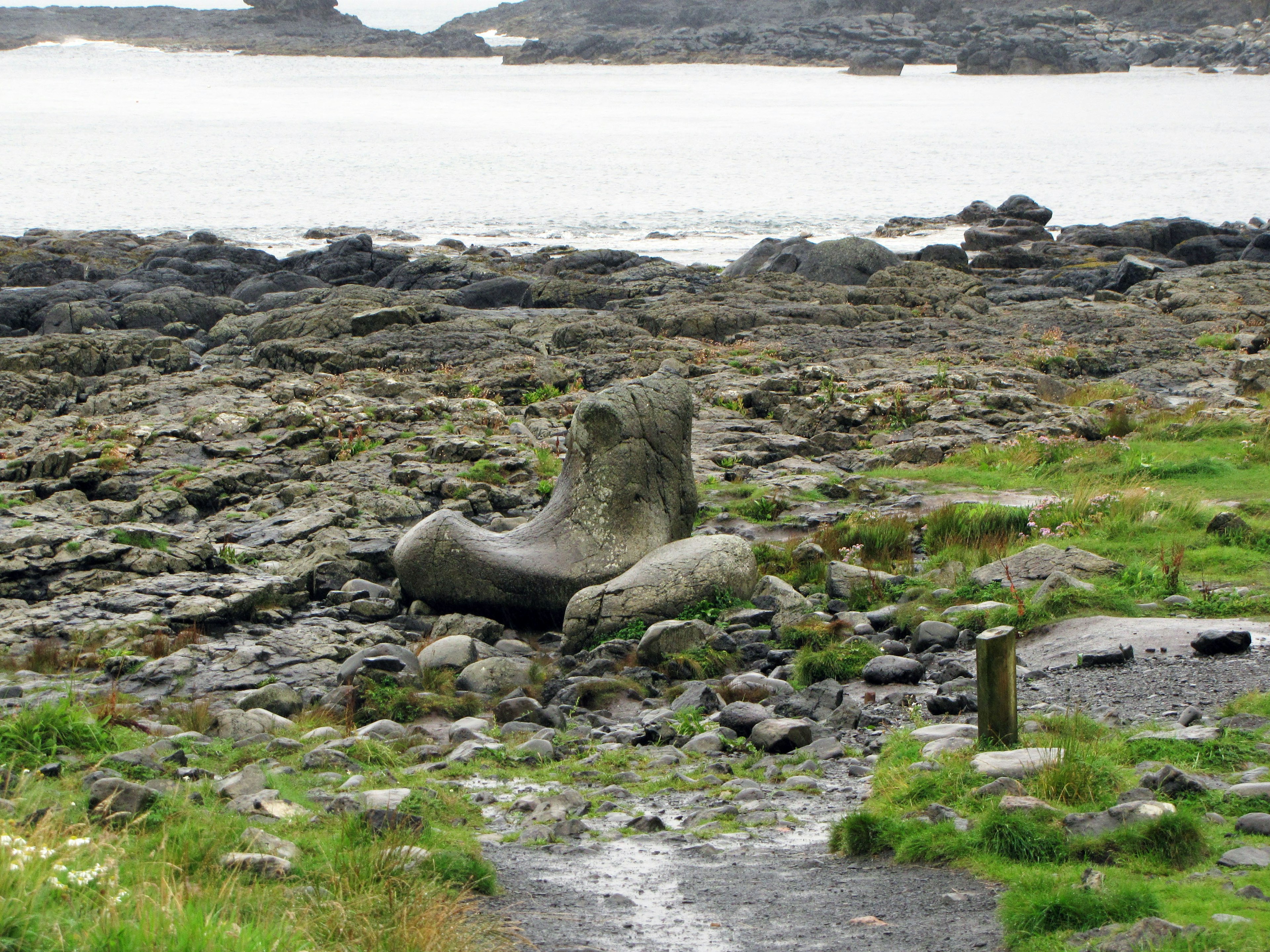 Grande formazione di pietra simile a una scultura su una costa rocciosa