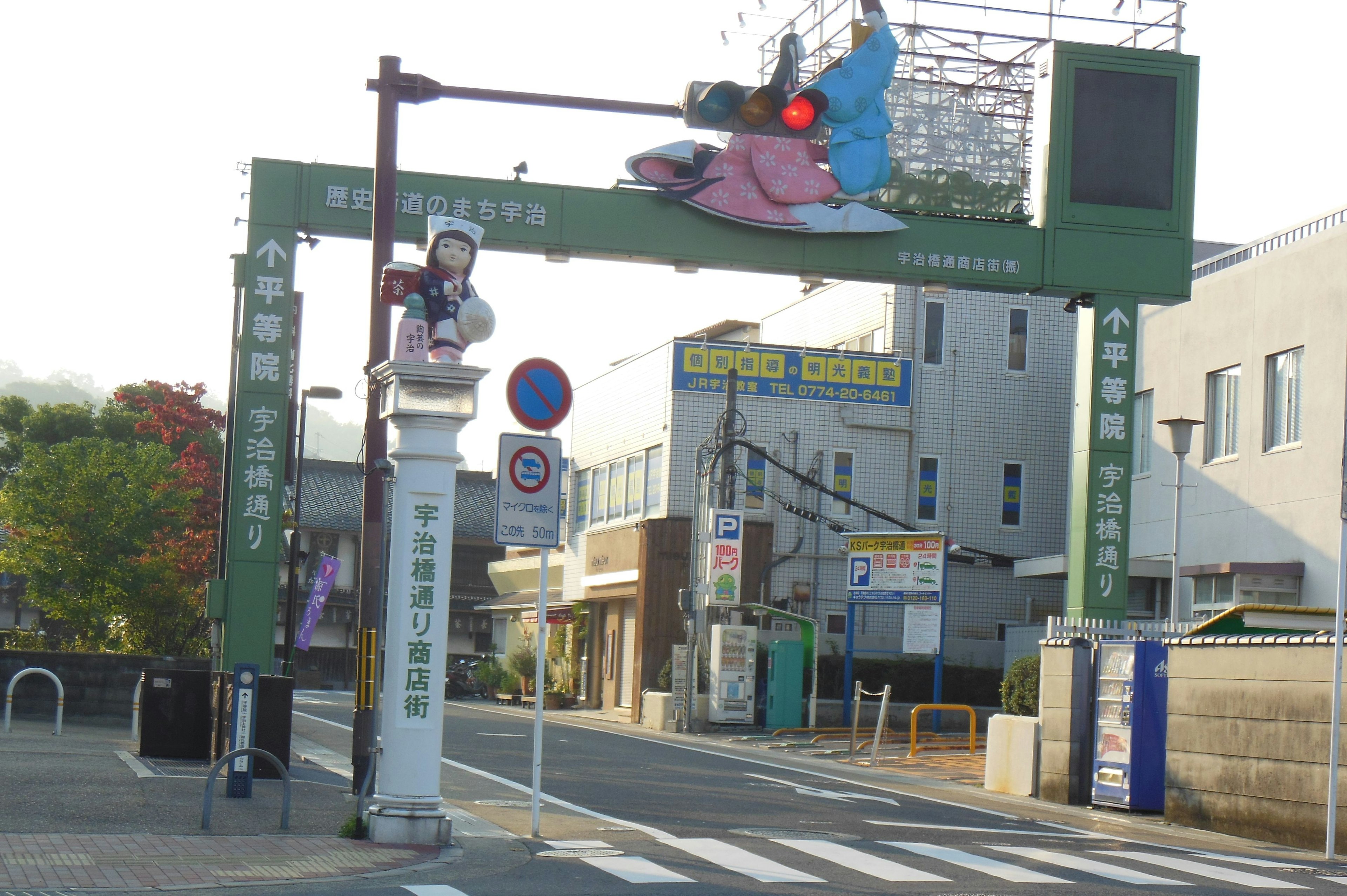 緑色のアーチの入口にある信号と街の風景