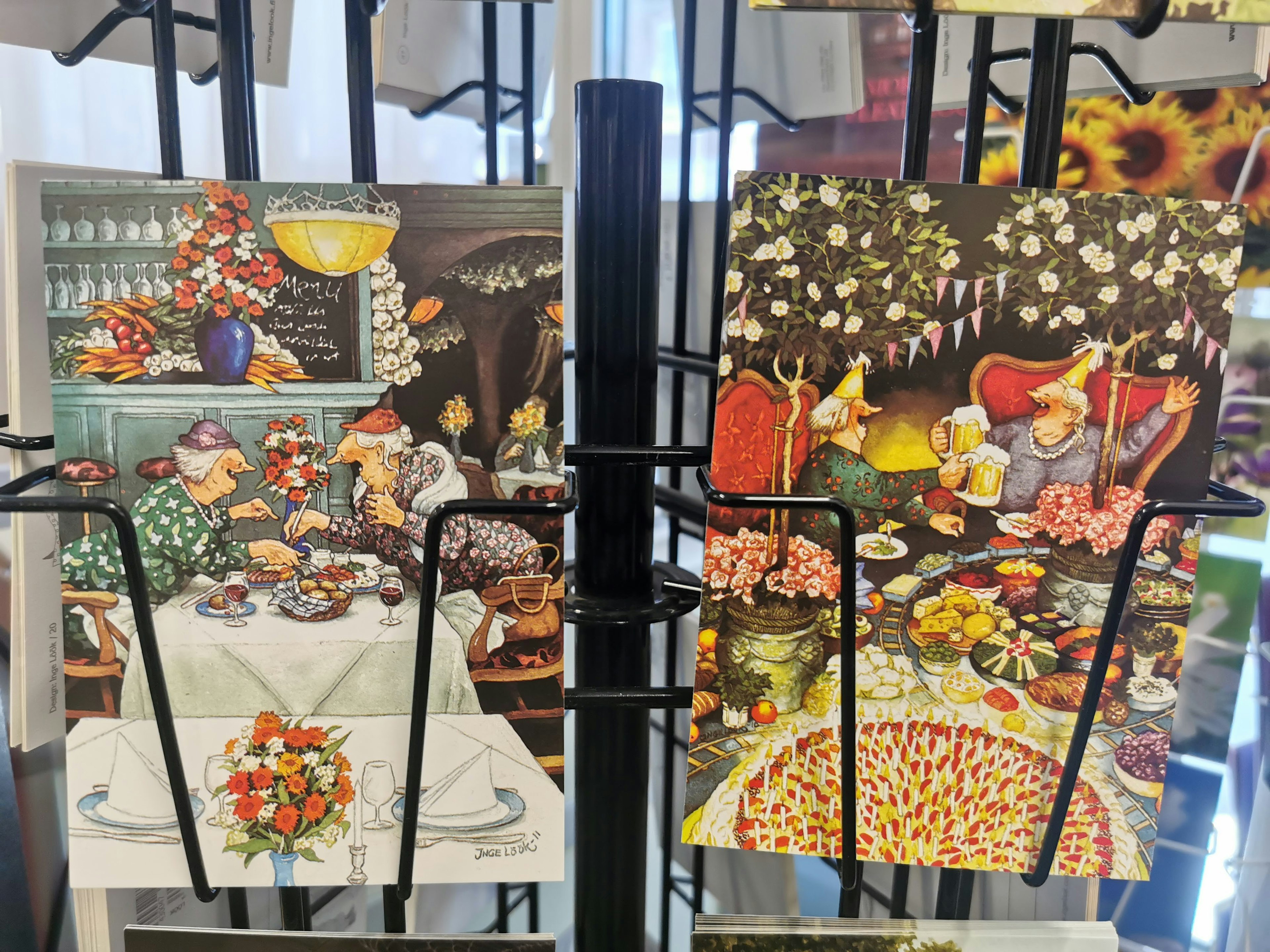 Display of colorful artwork featuring dishes and flowers