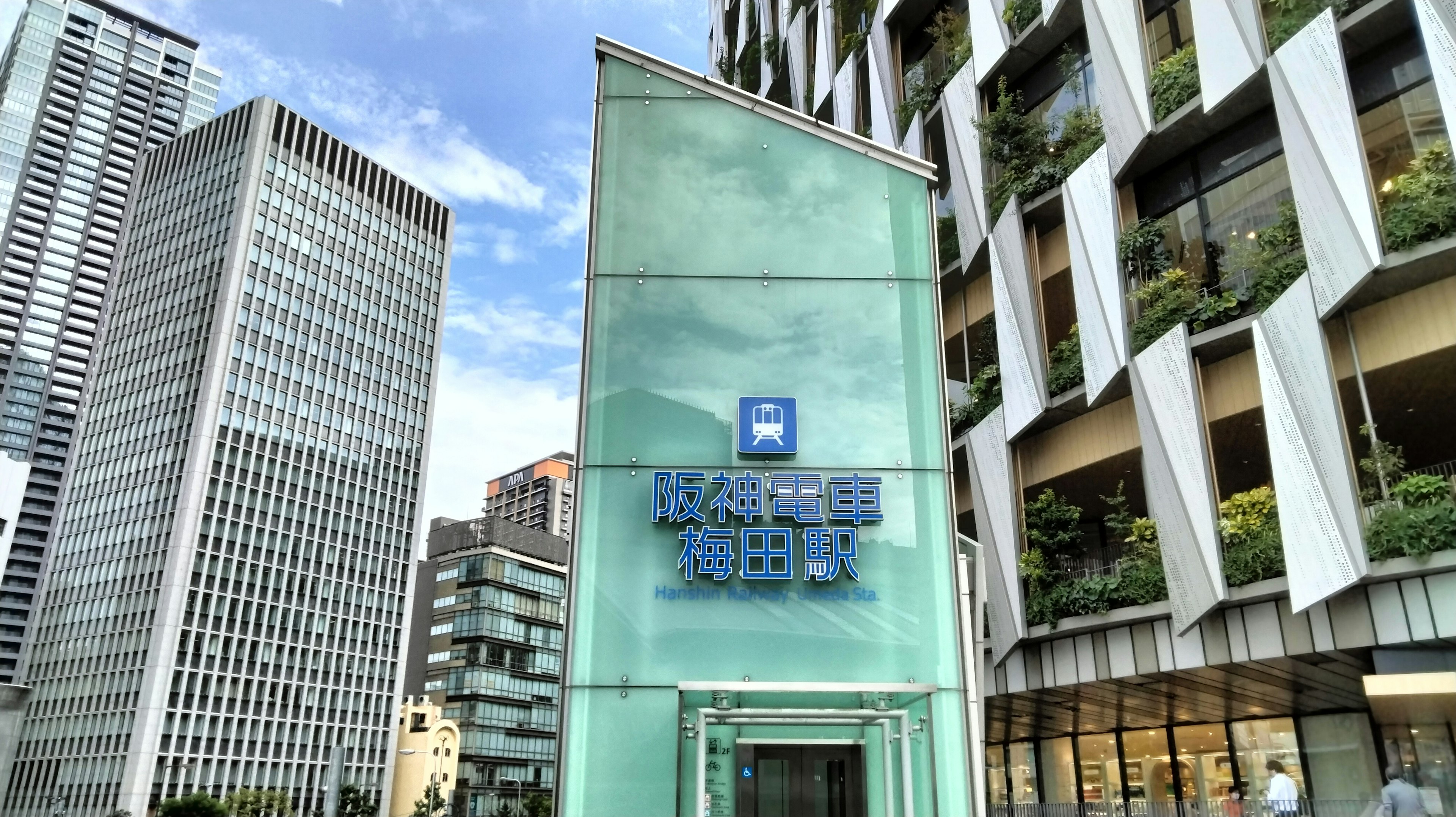 Extérieur d'un bâtiment moderne avec un panneau bleu et une structure en verre